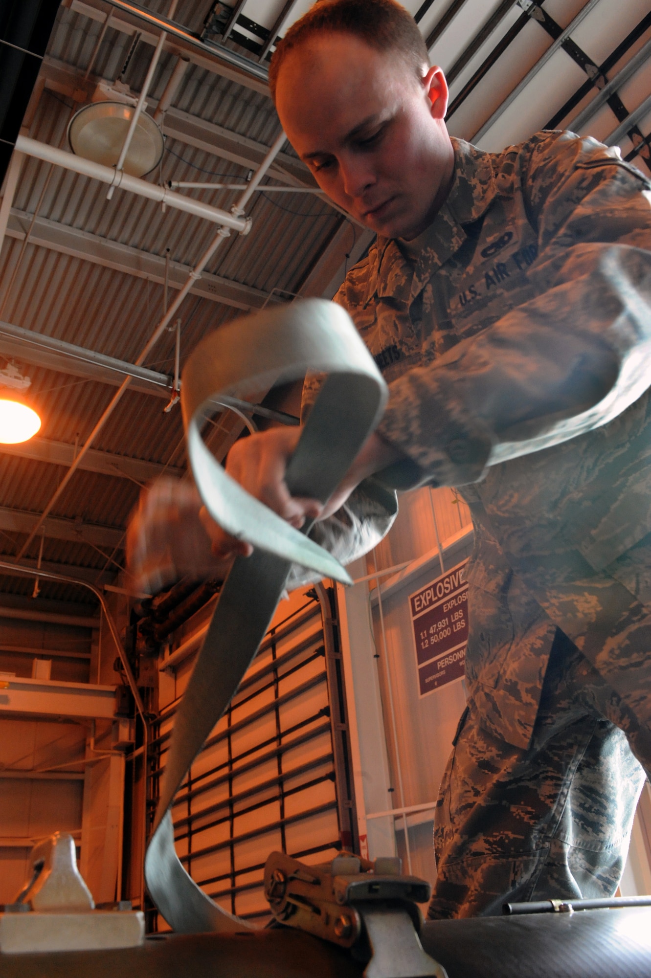 MINOT AIR FORCE BASE, N.D. – Airman 1st Class Christopher Sheets, 5th Munitions Squadron maintenance crew member, fastens a harness to secure an inert laser guided bomb onto a munitions handling unit trailer at the conventional maintenance shop on Minot Air Force Base March 9. Conventional maintenance crew members conduct familiarization and characteristic training with loading and assembling bombs to meet armor load standardizations in support for the 23rd and 69th Bomb Squadrons. (U.S. Air Force photo by Senior Airman Jesse Lopez)