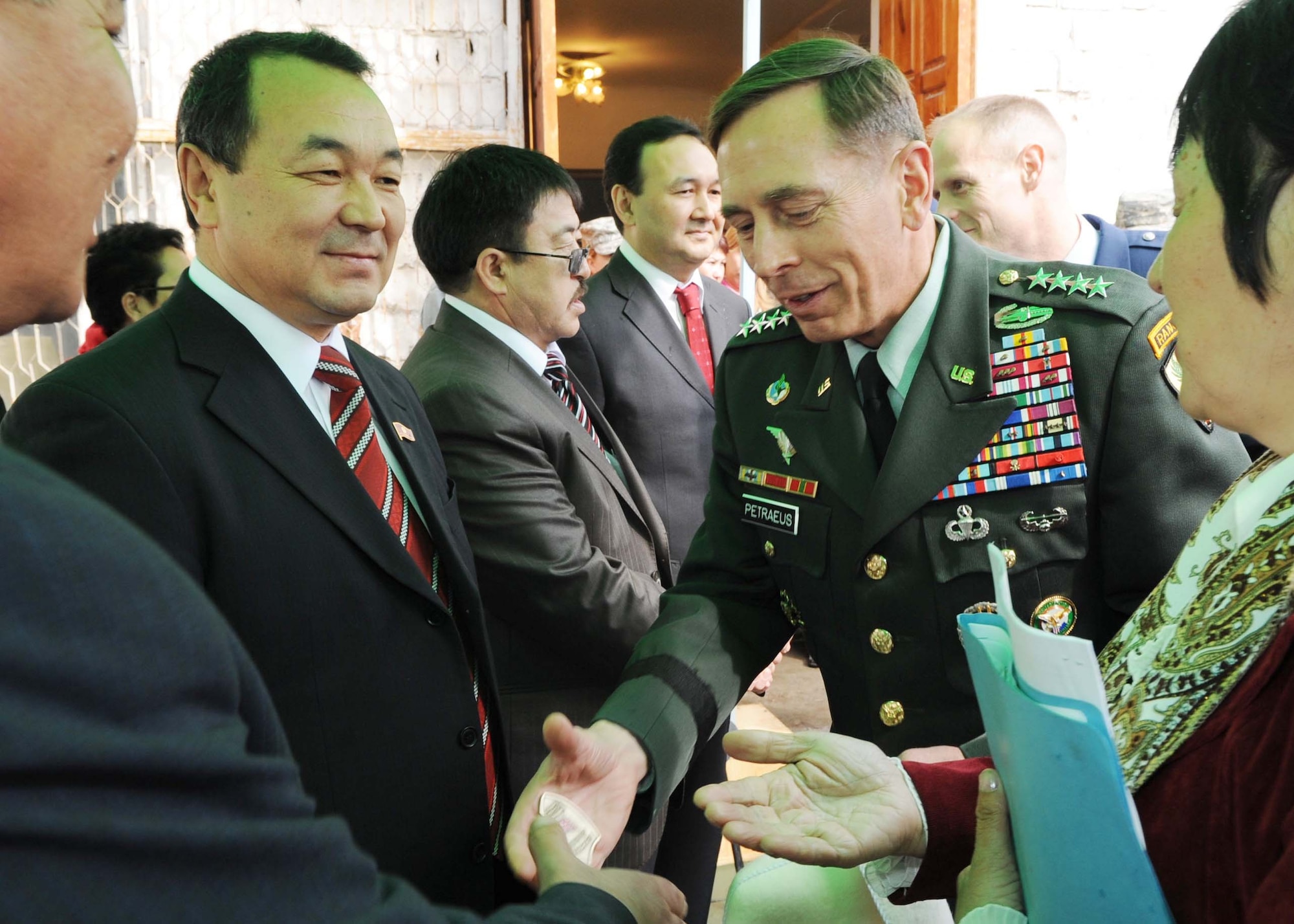 U.S. Army Gen. David Petraeus, Commander, U.S. Central Command, greets Kyrgyz government officials and presents Gov. of Chuy Province Mr. Bolotkon Kumarov a coin before the ground breaking ceremony for the Women's Center in Bishkek, Kyrgyzstan, March 11, 2010. (U.S. Air Force photo/Senior Airman Nichelle Anderson)

