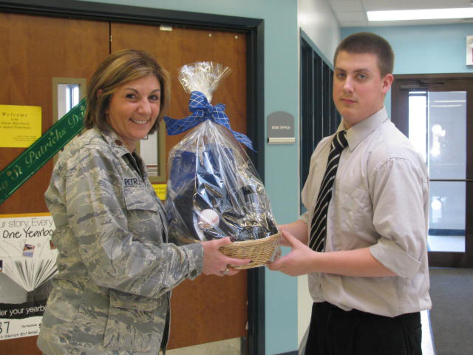 The ?Serving from Home: The American Military Family? essay contest second place contest winner Ken Voit from the Charter School for Applied Technologies, February 2, 2010, Buffalo, NY.  Presenting the runner up award to Ken is U.S. Air Force Major Andrea Pitruzzella. (Photo courtesy of the Charter School for Applied Technologies)                        