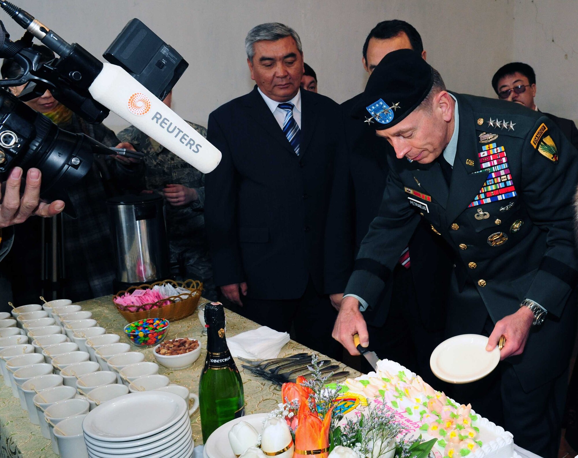 Army Gen. David Petraeus, Commander, U.S. Central Command, cuts the cake in front of international media during a ceremony at a building that will become the Women’s Center during his trip to Kyrgyzstan, March 11, 2010. (U.S. Air Force photo/Staff Sgt. Carolyn Viss/released)