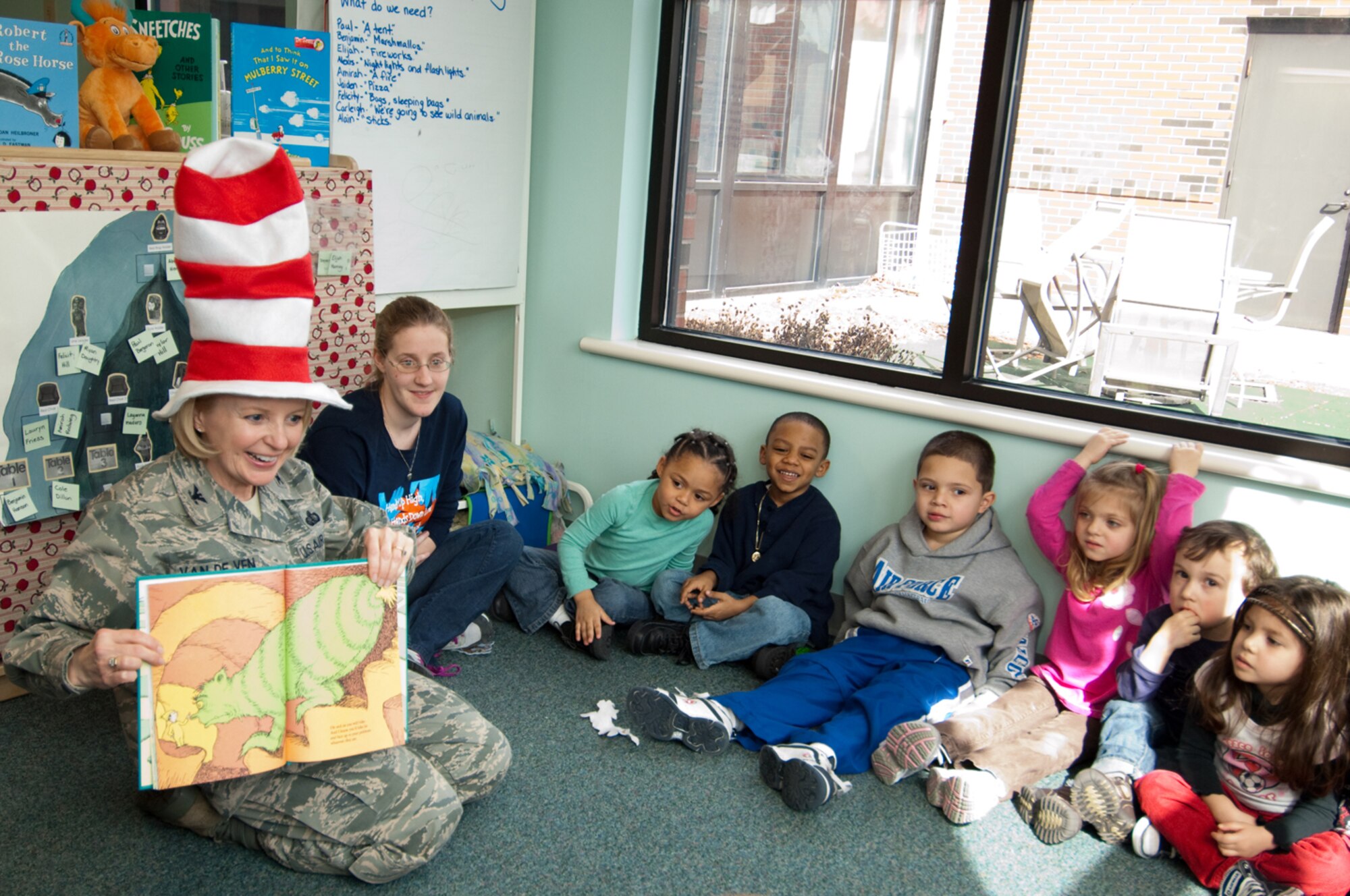 Children at the Child Development Center listen closely as Col. Deborah Van De Ven, 66th Mission Support Group commander, entertains them by reading a Dr. Seuss book. The CDC hosted guest readers throughout the day on March 2 to highlight the importance of reading to children as part of the National Education Association's Read Across America campaign. (U.S. Air Force photo by Rick Berry)
