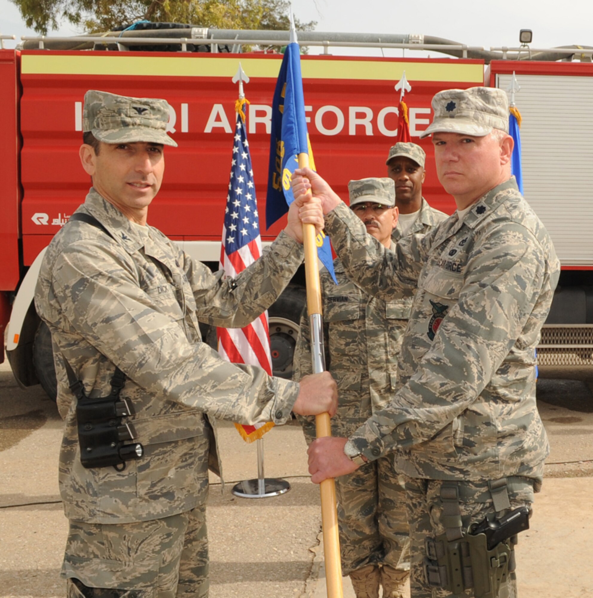 Col. Leonard Dick, 506th Expeditionary Group commander, passes a guidon to Lt. Col. William Reihl 506th Expeditionary Civil Engineer Squadron commander, during a change of command ceremony at Kirkuk Regional Air Base, Iraq on March 5th, 2010. Colonel Reihl is deployed from Homestead Air Reserve Base, Fla.. (U.S. Air Force photo/Staff Sgt. Tabitha Kuykendall/Released)
