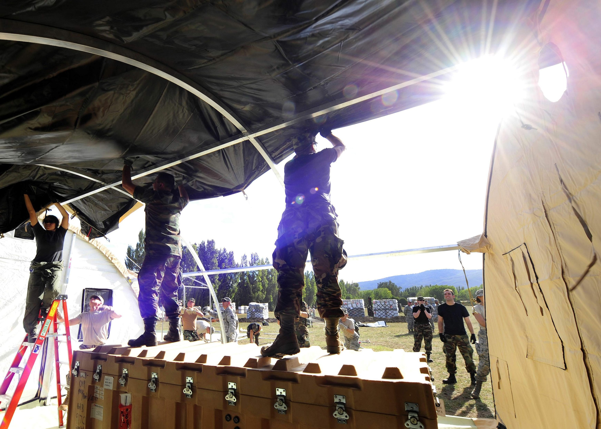 Airmen from an Air Force Expeditionary Medical Support team along with members of the Chilean army build a mobile hospital March 10, 2010, in Angol, Chile. About 60 medical Airmen will work alongside local Chilean medics to provide medical support to the local community. (U.S. Air Force photo/Senior Airman Tiffany Trojca)