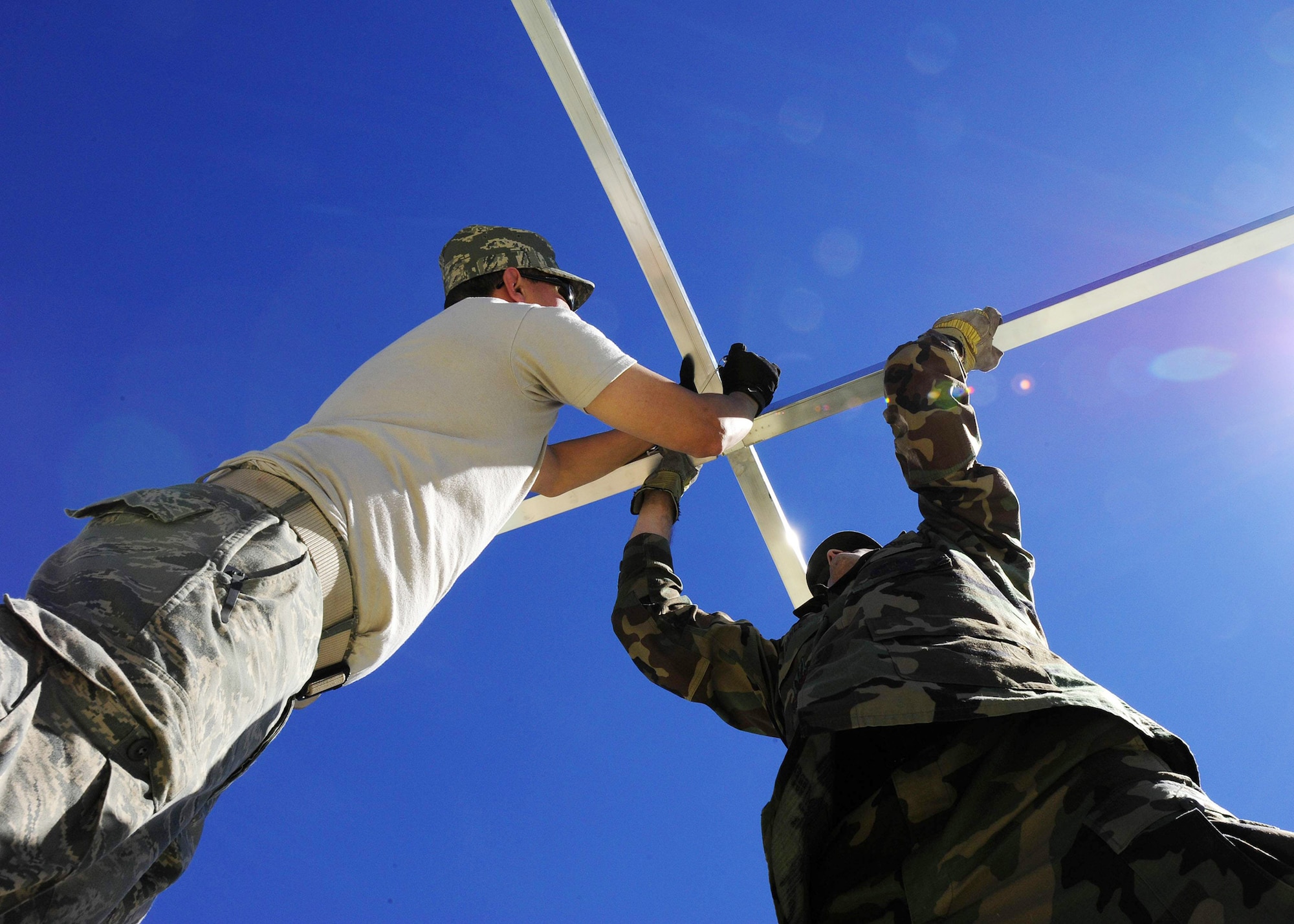 Staff Sgt. Abraham Rodriguez and Maj. James Dahle lock the cross bars of a newly constructed mobile hospital March 10, 2010, in Angol, Chile. The Airmen are part of an Air Force Expeditionary Medical Support team building a mobile hospital here to help augment medical services for nearly 110,000 Chileans in the region. Sergeant Rodriguez is a translator from the Air Force School of Aerospace Medicine at Brooks City-Base, Texas. Major Dahle is a 633rd Medical Operations Squadron emergency physician from Joint Base Langley-Eustis, Va. (U.S. Air Force photo/Senior Airman Tiffany Trojca)