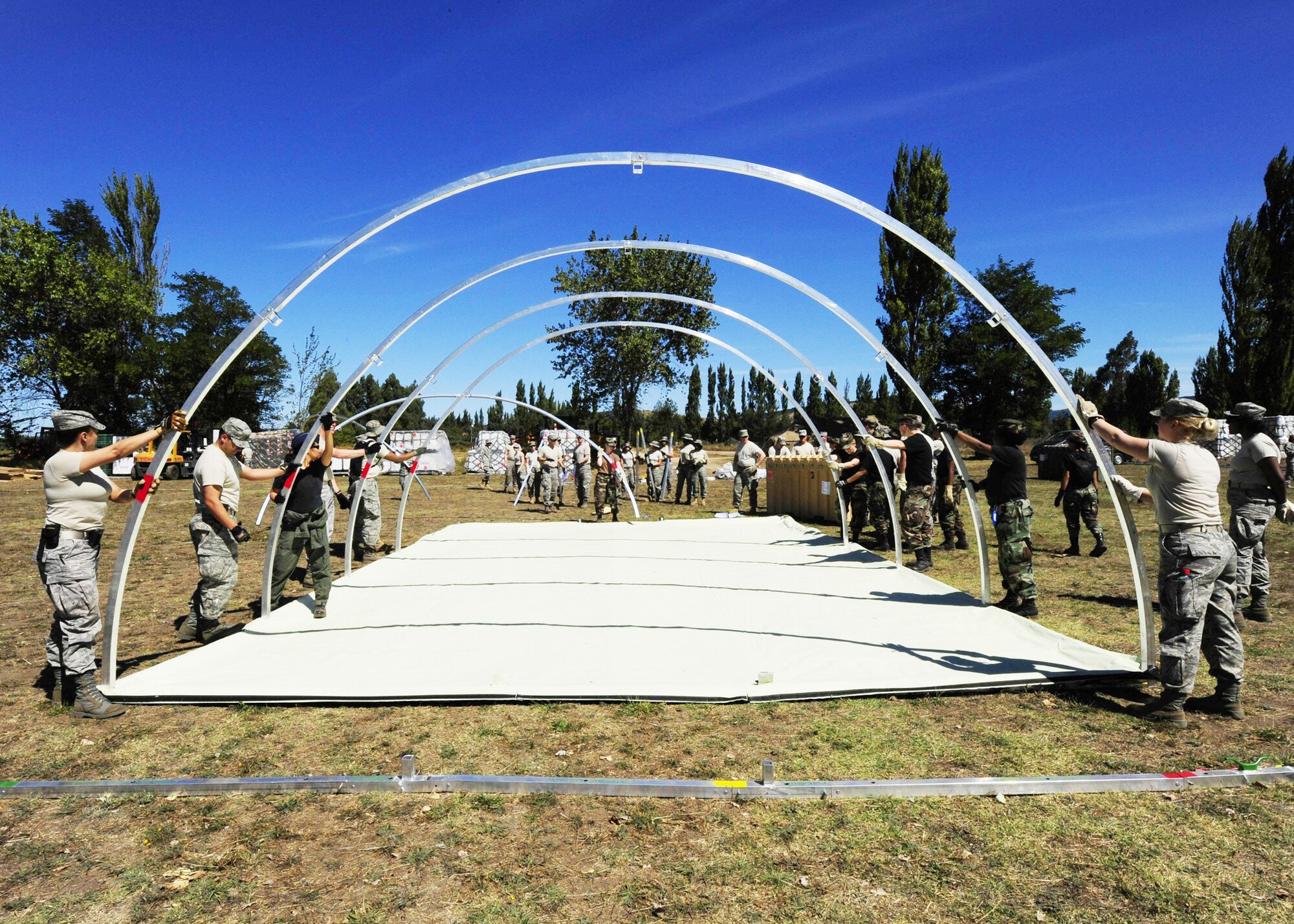 Airmen from an Air Force Expeditionary Medical Support team along with members of the Chilean army build a mobile hospital March 10, 2010, in Angol, Chile. About 60 medical Airmen will work alongside local Chilean medics to provide medical support to the local community. (U.S. Air Force photo/Senior Airman Tiffany Trojca)