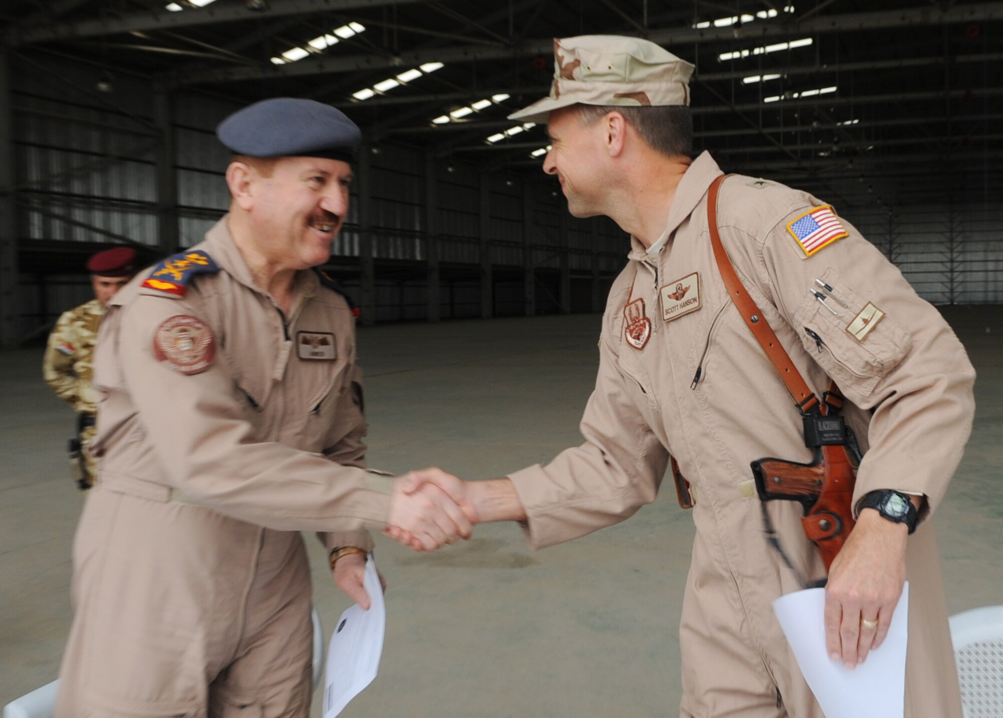 Members of the Iraq Training and Advisory Mission, U.S. Air Force and the Iraqi air force, participate in ribbon cutting ceremony on Kirkuk Regional Air Base, Iraq on March 10, 2010.  Brig. Gen. Scott Hanson, 321st Air Expeditionary Wing commander, and Staff Lt. Gen. Anwer Ameen, Iraqi air force commander, signed a letter of acceptance and transfer for the newly restored Skeleton Hangar. (U.S. Air Force photo/Staff Sgt. Tabitha Kuykendall/Released)		       