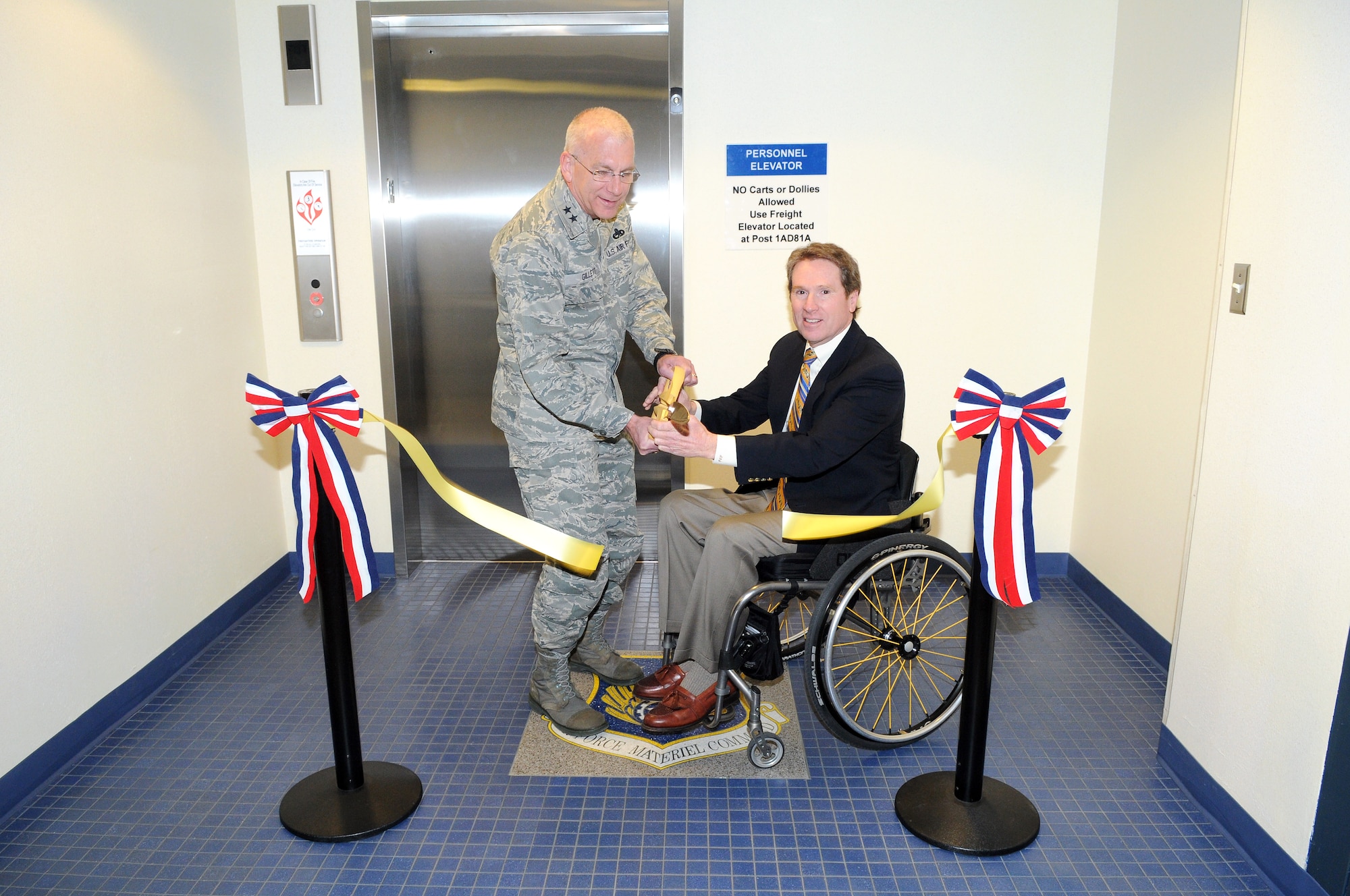 A ribbon cutting ceremony was held recently to officially open a new Americans With Disabilities Act-compliant elevator in Bldg. 3001. Performing the honors were Maj. Gen. David Gillett, Oklahoma City Air Logistics Center commander, and Steve Scalzo, 76th Maintenance Wing Business Operations Office director and co-chairman of Air Force Materiel Command People with Disabilities program. (Air Force photo)