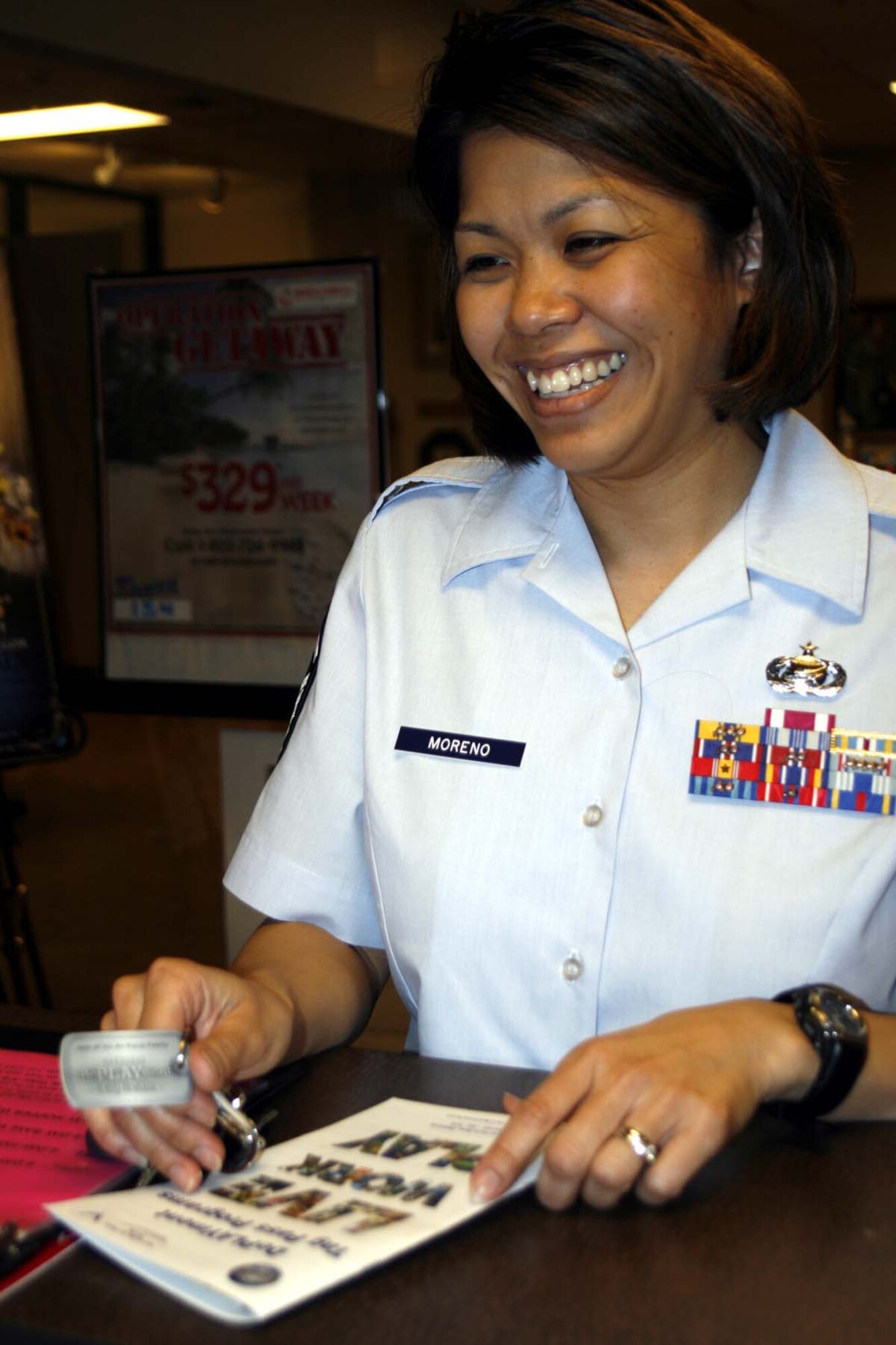 Master Sgt. Nickie Jay Moreno, 72nd Force Support Squadron, shows her DePLAYment tag while signing up for an Oklahoma tour at the Information, Ticket and Travel Office. (Air Force photo by Becky Pillifant)
