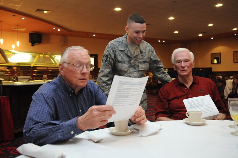RAF MILDENHALL, England – Stepping out of their space suits and acting as Public Affairs editors, Neil Armstrong (left) and Gene Cernan review the news story Tech. Sgt. Kevin Wallace (center) wrote about their participation in a March 11 “Legends of Aerospace: The Impossible Is Possible” tour at RAF Mildenhall’s Galaxy Club. In addition to the first and last astronauts to walk on the moon, the tour featured: Former “Good Morning America” host David Hartman, Apollo 13 commander Jim Lovell, last Air Force pilot ace Steve Ritchie, and SR-71 chief test pilot Bob Gilliland.  (U.S. Air Force photo/Staff Sgt. Austin May)