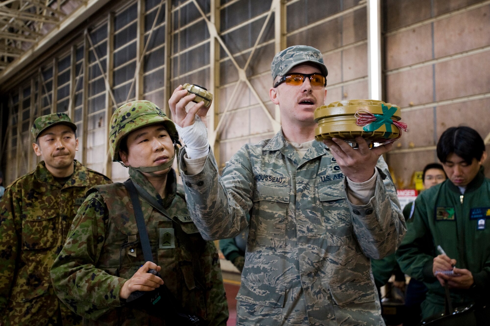 MISAWA AIR BASE, Japan -- Senior Airman Robert Brousseau, 35th Civil Engineer Squadron Explosive Ordnance Disposal journeyman, shows an example of a landmine to members of the Japan Air Self-Defense Force and Japan Ground Self-Defense  Force March 11 at Hangar 949. The training was in preparation for the annual, bilateral Guard and Protect exercise. (U.S. Air Force photo/Senior Airman Jamal D. Sutter)