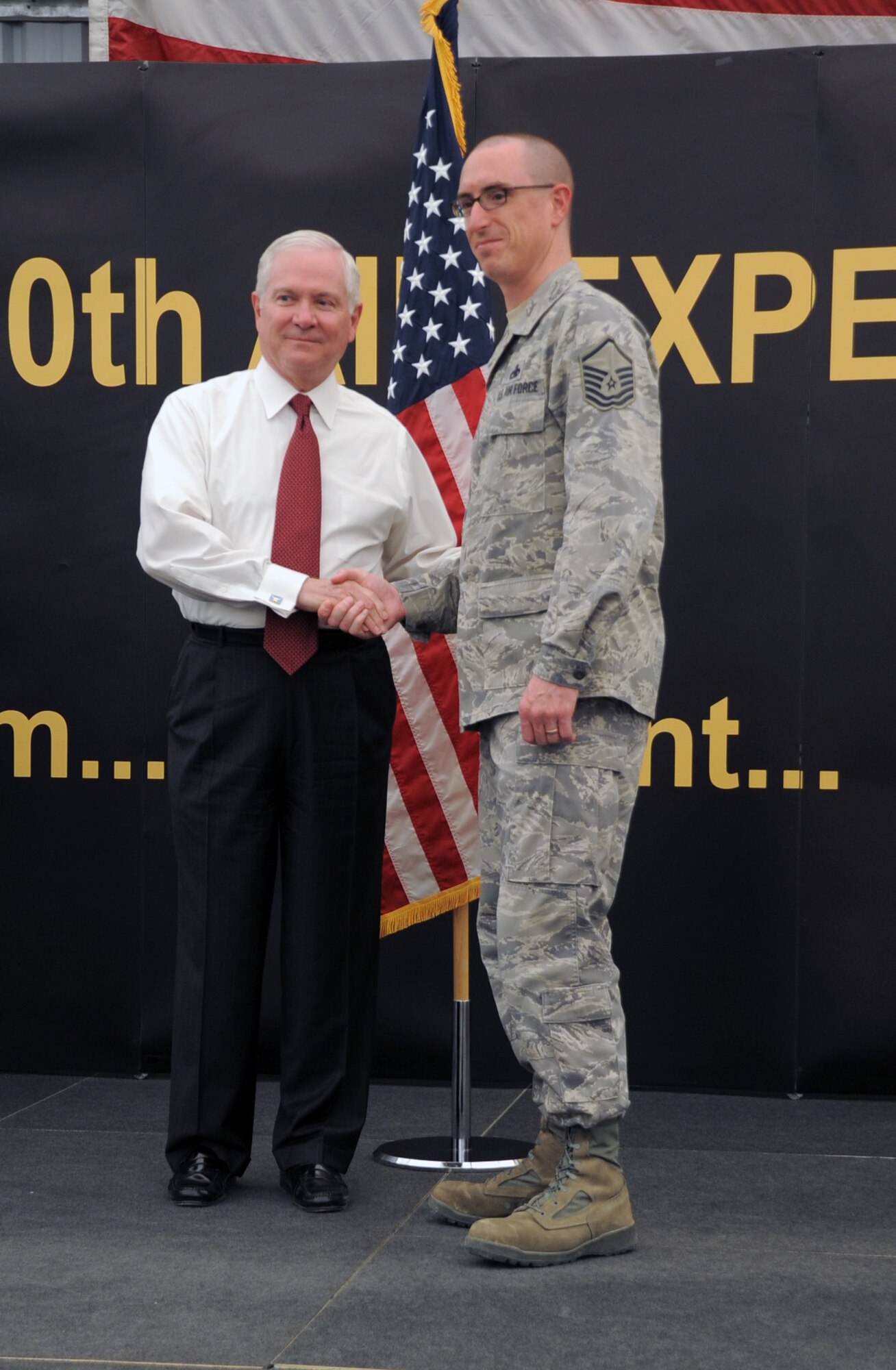 U.S. Defense Secretary Robert M. Gates presents a coin to Master Sgt. Daniel Stoick, superintendent for the 380th Expeditionary Maintenance Squadron Maintenance Operations Control during the secretary's visit to see the men and women of the 380th Air Expeditionary Wing at an non-disclosed location in Southwest Asia on March 11, 2010. During the town hall meeting, Secretary Gates gave some brief comments, answered questions from the deployed service members, and presented each in attendance with a coin.  The stop at the 380th AEW was part of Secretary Gates' trip through several countries meeting with U.S. allies.  (U.S. Air Force Photo/Master Sgt. Scott T. Sturkol/Released)
