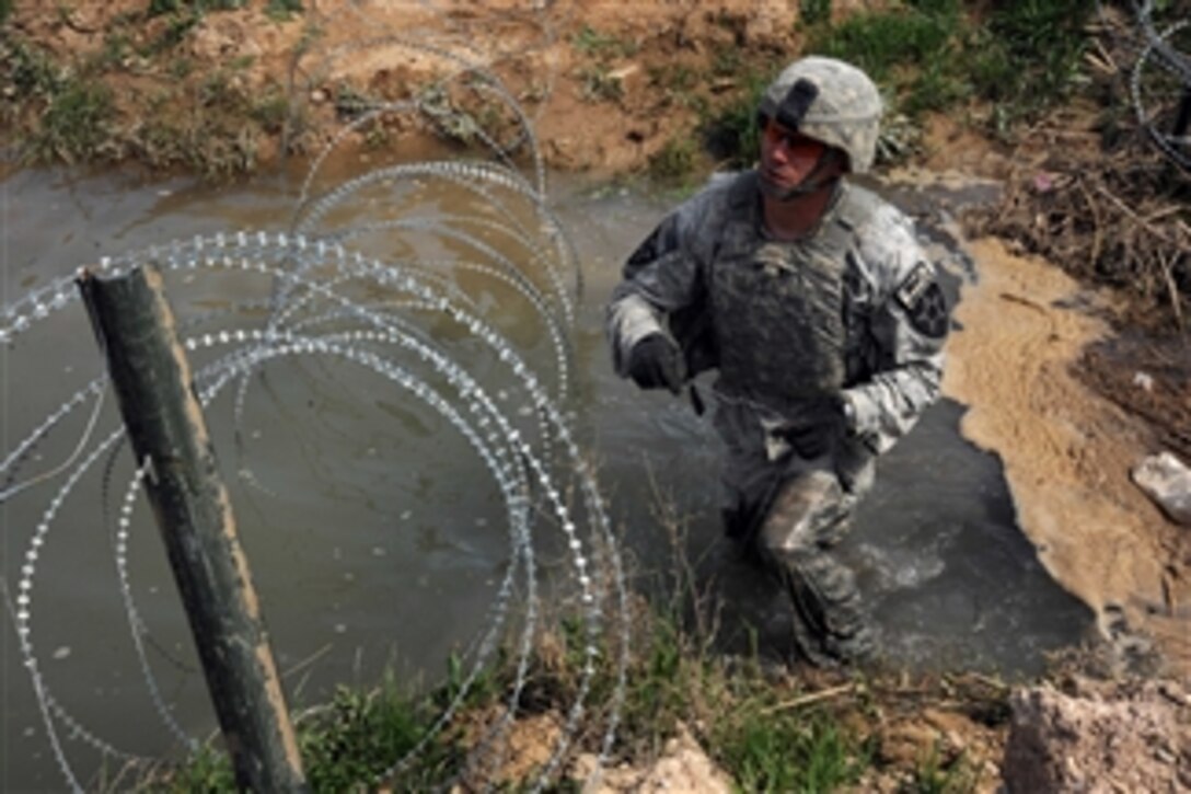 U.S. Army Spc. Louis Phay, with Alpha Company, 4th Battalion, 23rd Infantry Regiment, installs a culvert denial system along Highway 601 in the Helmand province of Afghanistan on March 6, 2010.  