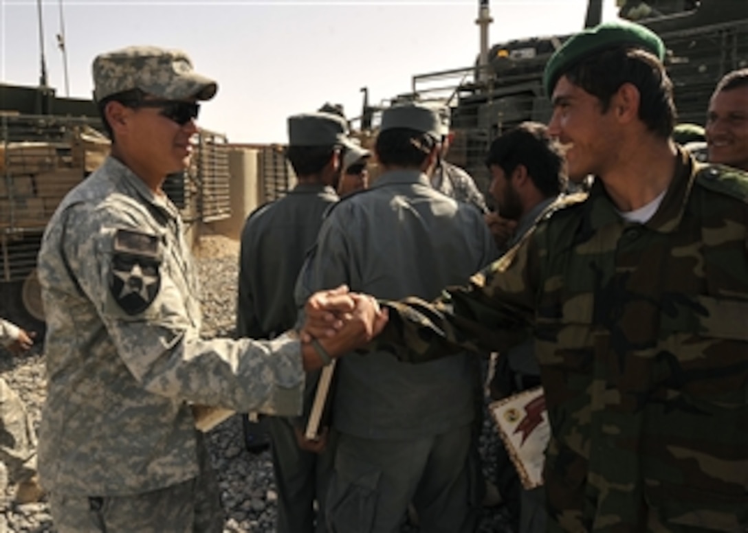 U.S. Army Sgt. Anthony Hernandez, with Blackwatch Company, 2nd Battalion, 1st Infantry Regiment, congratulates an Afghan National Army soldier during the Task Force Legion Academy graduation ceremony at Forward Operating Base Ramrod, Afghanistan, on March 7, 2010.  
