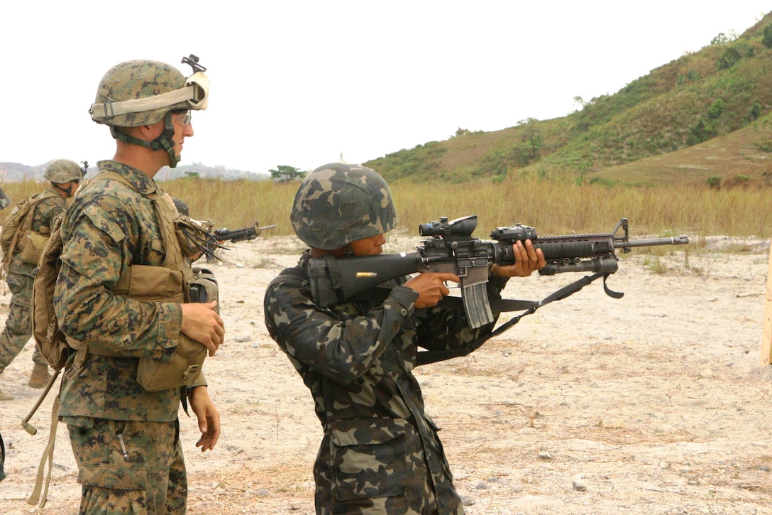 A Republic of the Philippines Marine fires rounds down range as a U.S. Marine with Battalion Landing Team 2nd Battalion, 7th Marines (BLT 2/7), 31st Marine Expeditionary Unit (MEU), instructs him during a small-arms shoot, March 13.  The small-arms shoot was part of bilateral training being conducted during exercise Balikatan 2010 (BK ’10).