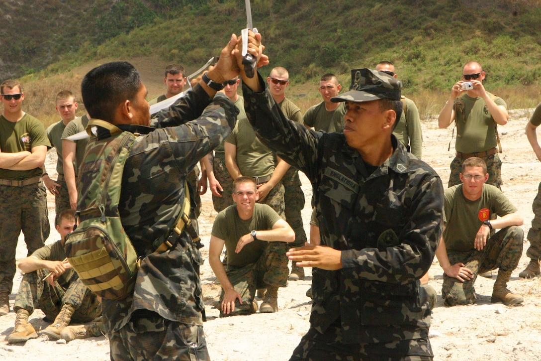 Tech Sgt. Manuel S Prado Jr. (left), a chief master instructor, and Staff Sgt. Carlito M Englatiera Jr. (right), a martial arts instructor, both with the Republic of the Philippines Marine Corps Martial Arts Program demonstrate Pekithtirsia defense moves to U.S. Marines with Battalion Landing Team 2nd Battalion, 7th Marines (BLT 2/7), 31st Marine Expeditionary Unit (MEU), March 13.  The martial arts class was part of bilateral training being conducted during exercise Balikatan 2010 (BK ’10). (Official Marine Corps photo by Cpl. Michael A. Bianco)