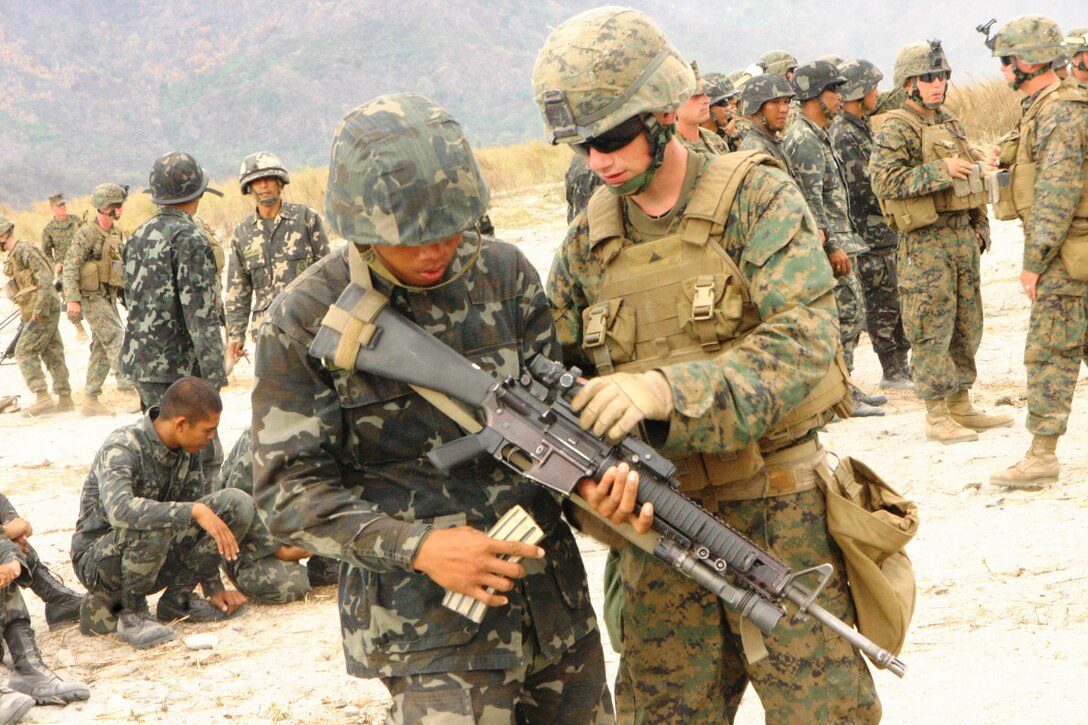 A Republic of the Philippines Marine learns about the M16 A4 service rifle from a U.S. Marine with Battalion Landing Team 2nd Battalion, 7th Marines (BLT 2/7), 31st Marine Expeditionary Unit (MEU), looks on during a small-arms shoot, March 13.  The small-arms shoot was part of bilateral training being conducted during exercise Balikatan 2010 (BK ’10).