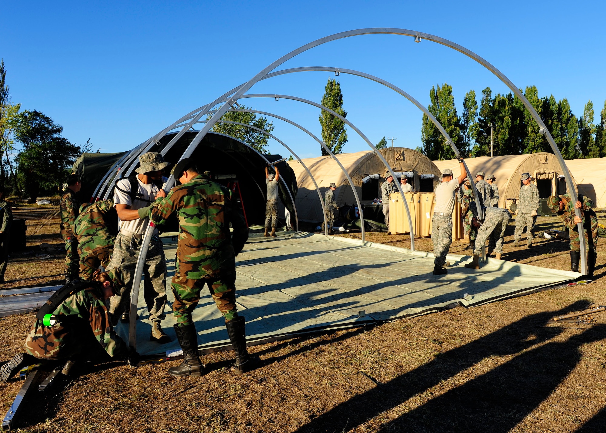 Chilean soldiers help Airmen from an Air Force Expeditionary Medical Support team erect an additional hospital tent March 12, in Angol, Chile. The additional tent will help meet the medical needs of the local community. (U.S. Air Force photo/Senior Airman TIffany Trojca)
