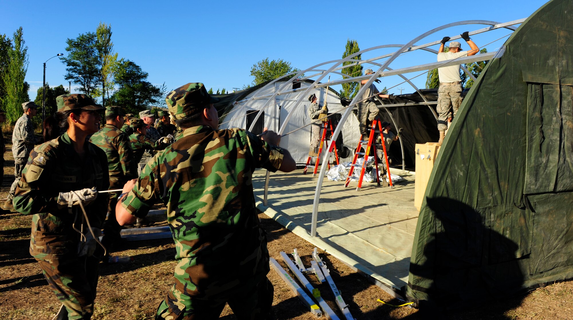 Chilean soldiers help Airmen from an Air Force Expeditionary Medical Support team erect an additional hospital tent March 12, in Angol, Chile. The additional tent will help meet the medical needs of the local community. (U.S. Air Force photo/Senior Airman TIffany Trojca)
