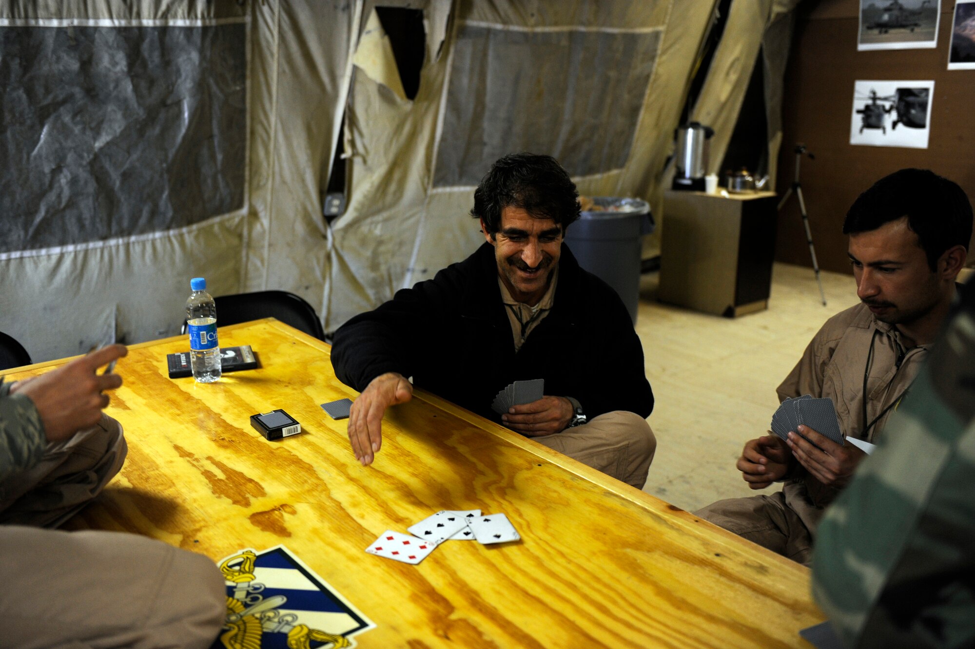Afghan National Army Air Corps crew chiefs pass the time prior to a flight, with a game of Spades, March 1, 2010, at Bagram Airfield, Afghanistan. (U.S. Air Force photo/Staff Sgt. Manuel J. Martinez/released)
