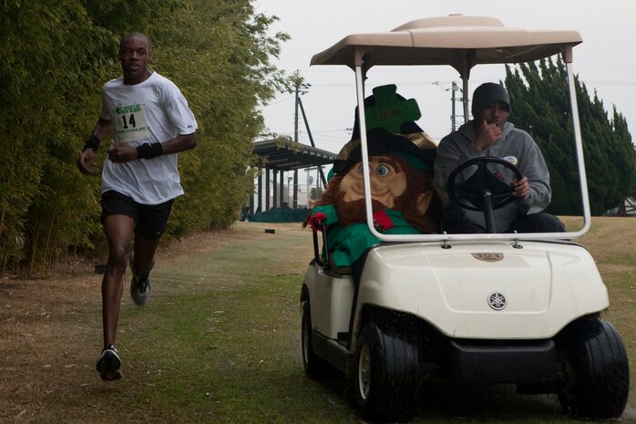 Teran Robinson runs side-by-side with the leprechaun’s golf cart just before crossing the finish line during the 2010 Run on the Green at Torii Pines golf course here March 13. Robinson took first place for the 17–29 year-old age group and the best 5K finish-time overall with a time of 18 minutes and 22 seconds.