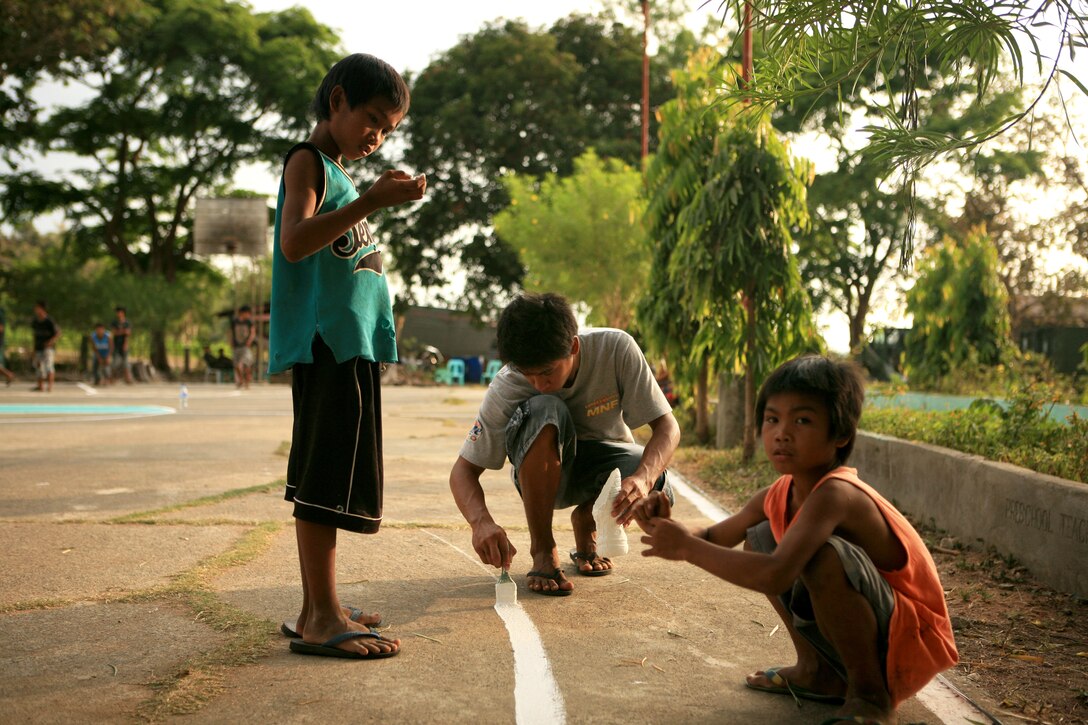 Local children of the Marnay community help paint lines on a basketball court during a renovation project at Marnay Primary School, March 14. Combat Logistics Battalion 31 (CLB-31), 31st Marine Expeditionary Unit (MEU), is helping renovate the school in support of exercise Balikatan 2010 (BK ’10). Servicemembers from the Armed Forces of the Philippines (AFP) and the 31st MEU are working together in an engineering civil affairs project (ENCAP) to provide renovation and community building projects during BK ’10. (Official Marine Corps photo by Lance Cpl. Dengrier M. Baez)