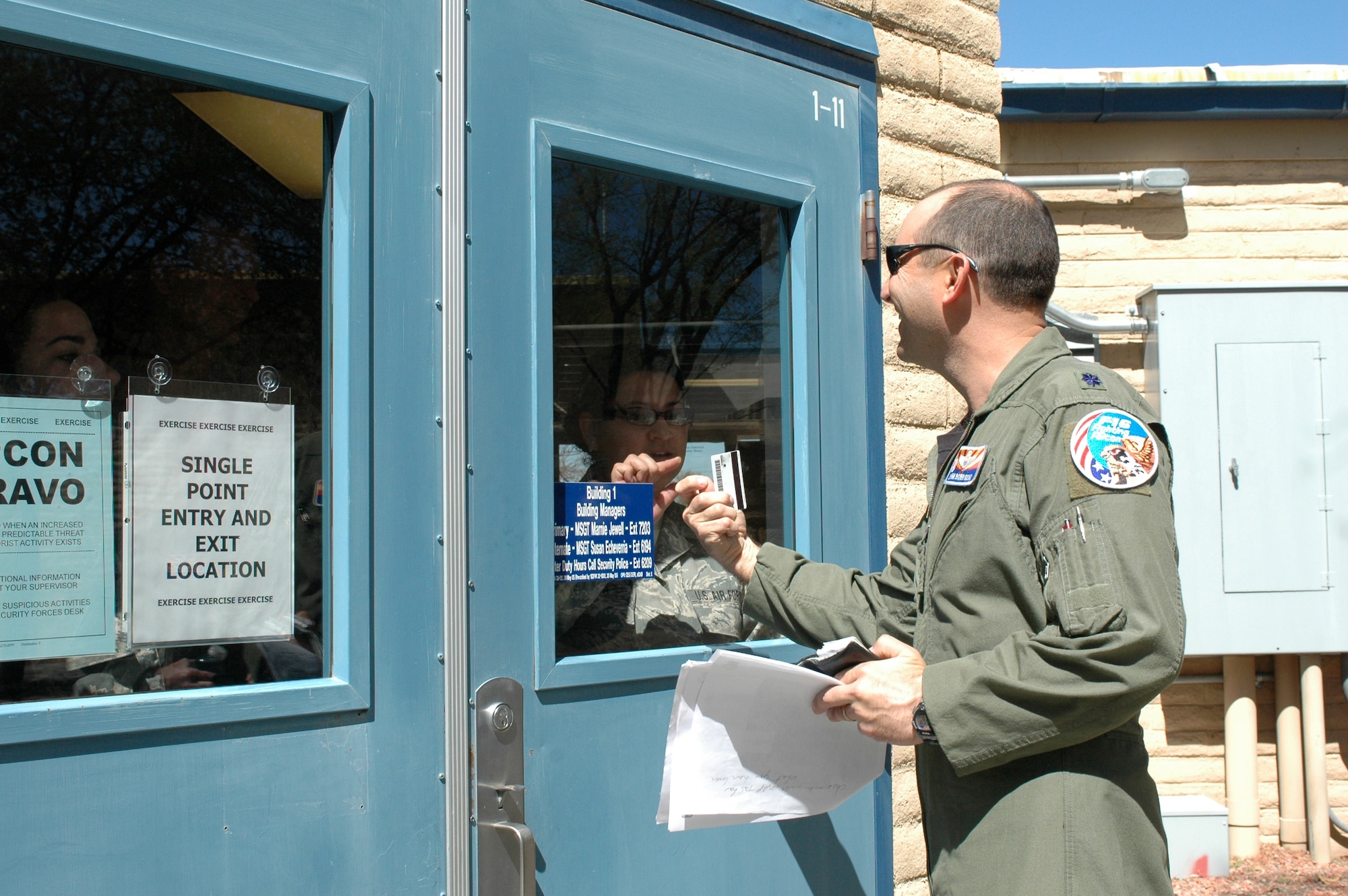Tech. Sgt. Maria Breceda, from the 162nd Force Support Squadron, checks the identification of Lt. Col. John Bobroski, the wing’s Air Force Advisor, before entering the wing headquarters building March 13 as part of a compliance inspection exercise. The 162nd Fighter Wing at Tucson International Airport is hosting an inspection team from Air Education and Training Command March 10-16. (Air Force photo by Tech. Sgt. Desiree Twombly)