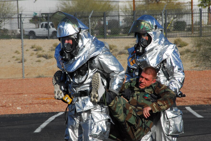 First responders from the base fire station carry an injured Guardsman to safety during a simulated accident March 12 as part of a compliance inspection exercise. The 162nd Fighter Wing at Tucson International Airport is hosting an inspection team from Air Education and Training Command March 10-16. (Air Force photo by Master Sgt. Dave Neve)