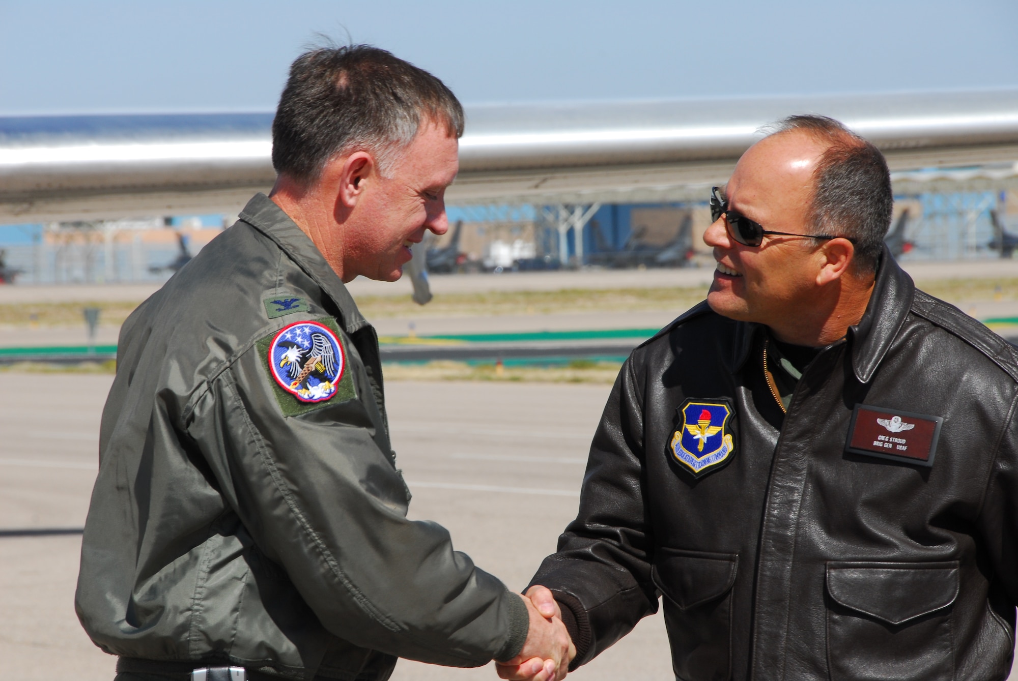 Col. Brian Akins, 19th Air Force Guard Advisor, is greeted by Brig. Gen. Greg Stroud, 162nd Fighter Wing commander, on the flightline at Tucson International Airport, March 10. Colonel Akins and an inspection team from Air Education and Training Command visited the Arizona Air Guard fighter wing for a compliance inspection this month.