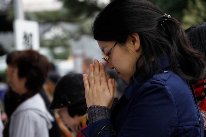 A Festival goer prays in front of the Tagata Shinto fertility shrine during the Hounen Matsuri, or abundant year festival, March 15. During the festival, people from all over Japan visit the shrine to pray for a blessed conception or to give thanks for a child who was born healthy.