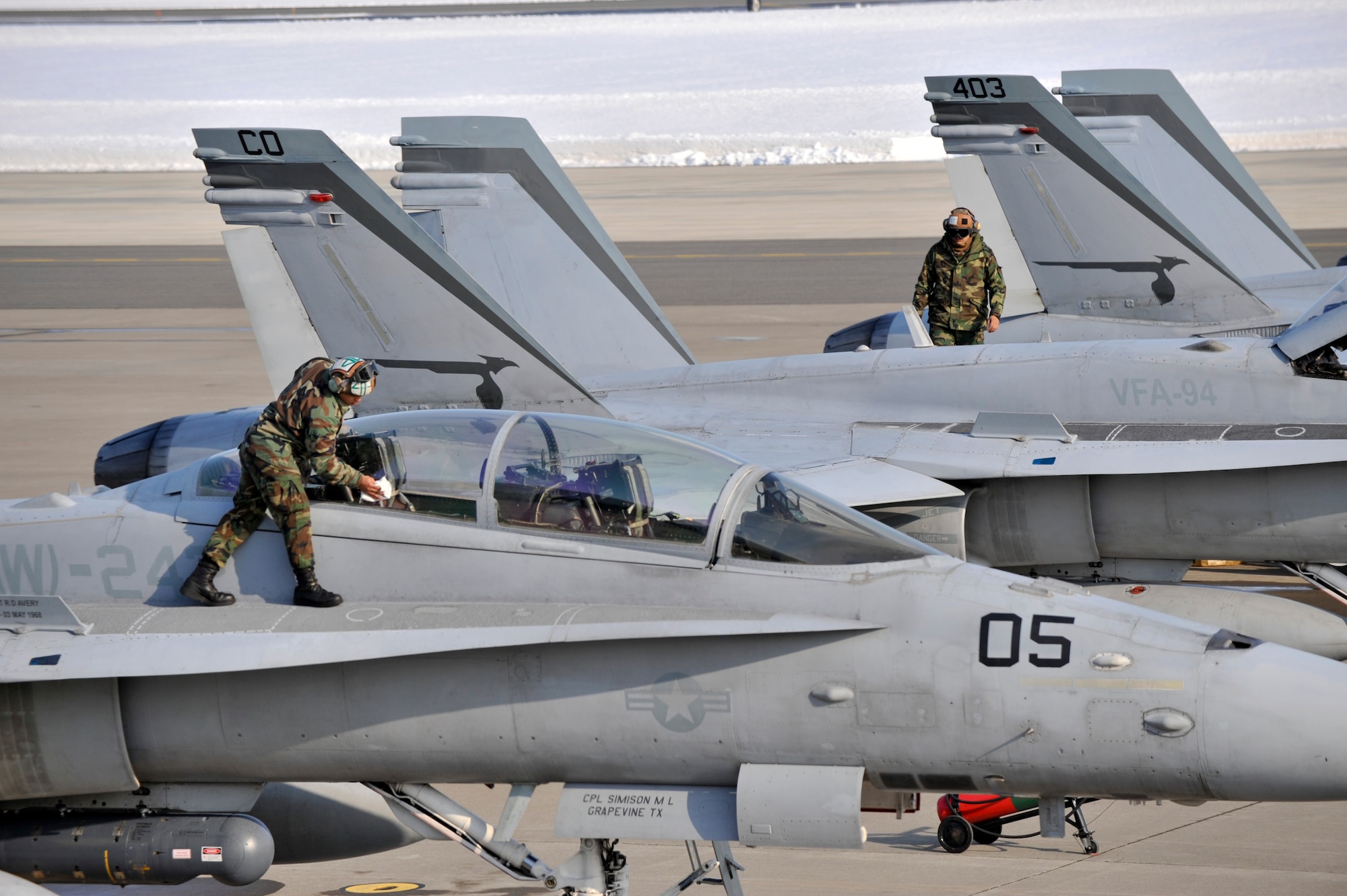 MISAWA AIR BASE, Japan -- Maintenance crews with the Vertical Fighter Attack Squadron 94 inspect and clean the top surfaces of their F/A-18 Hornets prior to a training flight March 12. Misawa's heavy snow during the week presented unique training opportunities for the unit based out of California. (U.S. Air Force photo/Staff Sgt. Samuel Morse)
