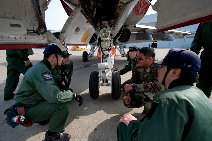 MISAWA AIR BASE, Japan -- U.S. Navy Petty Officer 1st Class James Mendiola, Vertical Fighter Attack Squadron 94 line division lead petty officer, explains the landing gear of an F/A-18 Hornet to Japan Air Self-Defense Force ground crews on the flightline March 12. After a week-long bilateral aviation training relocation exercise, the Navy and JASDF crews were given a chance to see each other's jets up close. (U.S. Air Force photo/Staff Sgt. Samuel Morse)