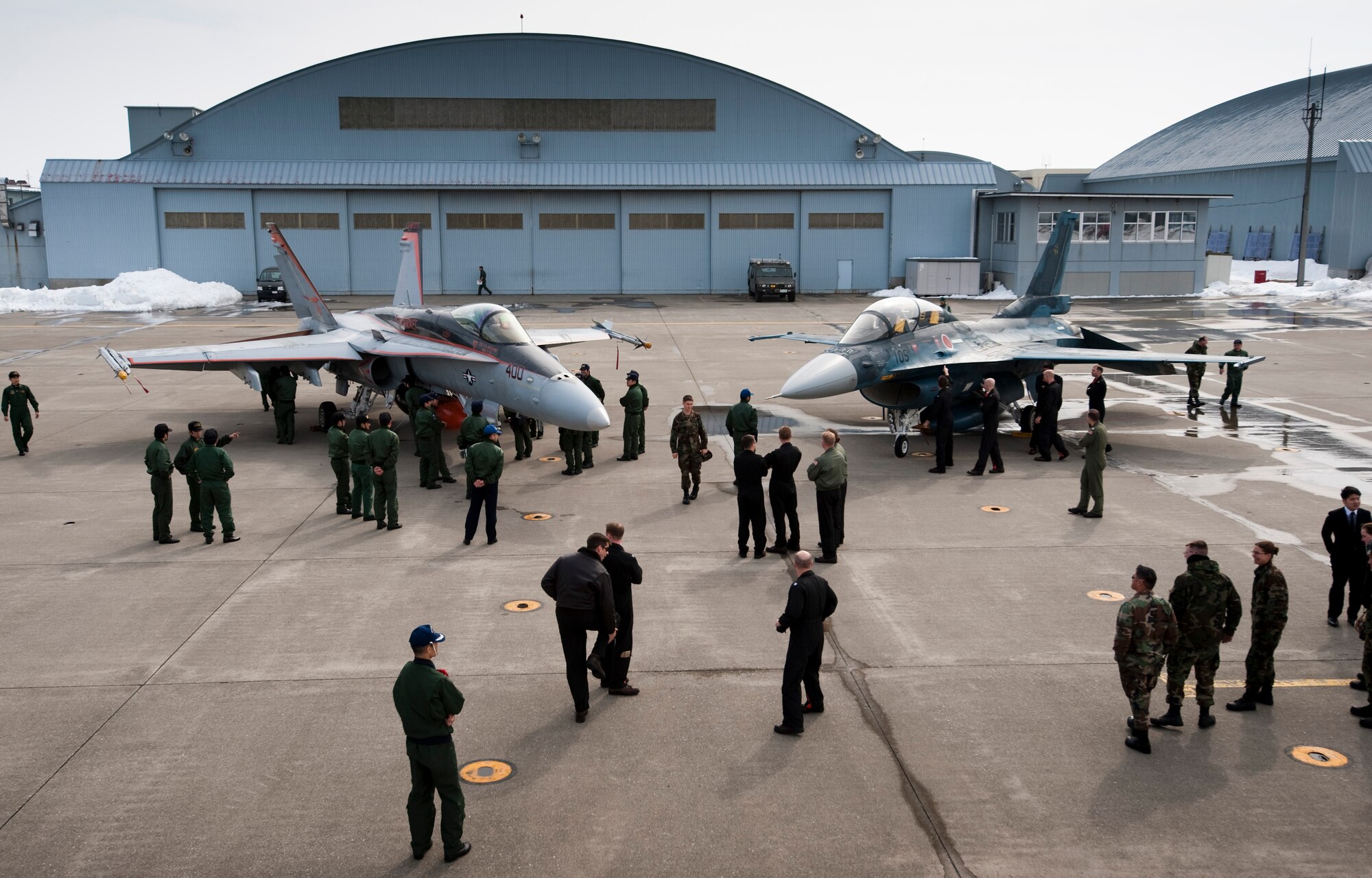 MISAWA AIR BASE, Japan -- Members of the U.S. Navy Vertical Fighter Attack Squadron 94 and Japan Air Self Defense Force 3rd Air Wing talk to each other and compare the mechanics of each other's jets March 12. VFA 94 visited Misawa to train with the JASDF, creating an opportunity for unique training as well as building a greater working relationship with their Japanese counterparts. (U.S. Air Force photo/Staff Sgt. Samuel Morse)