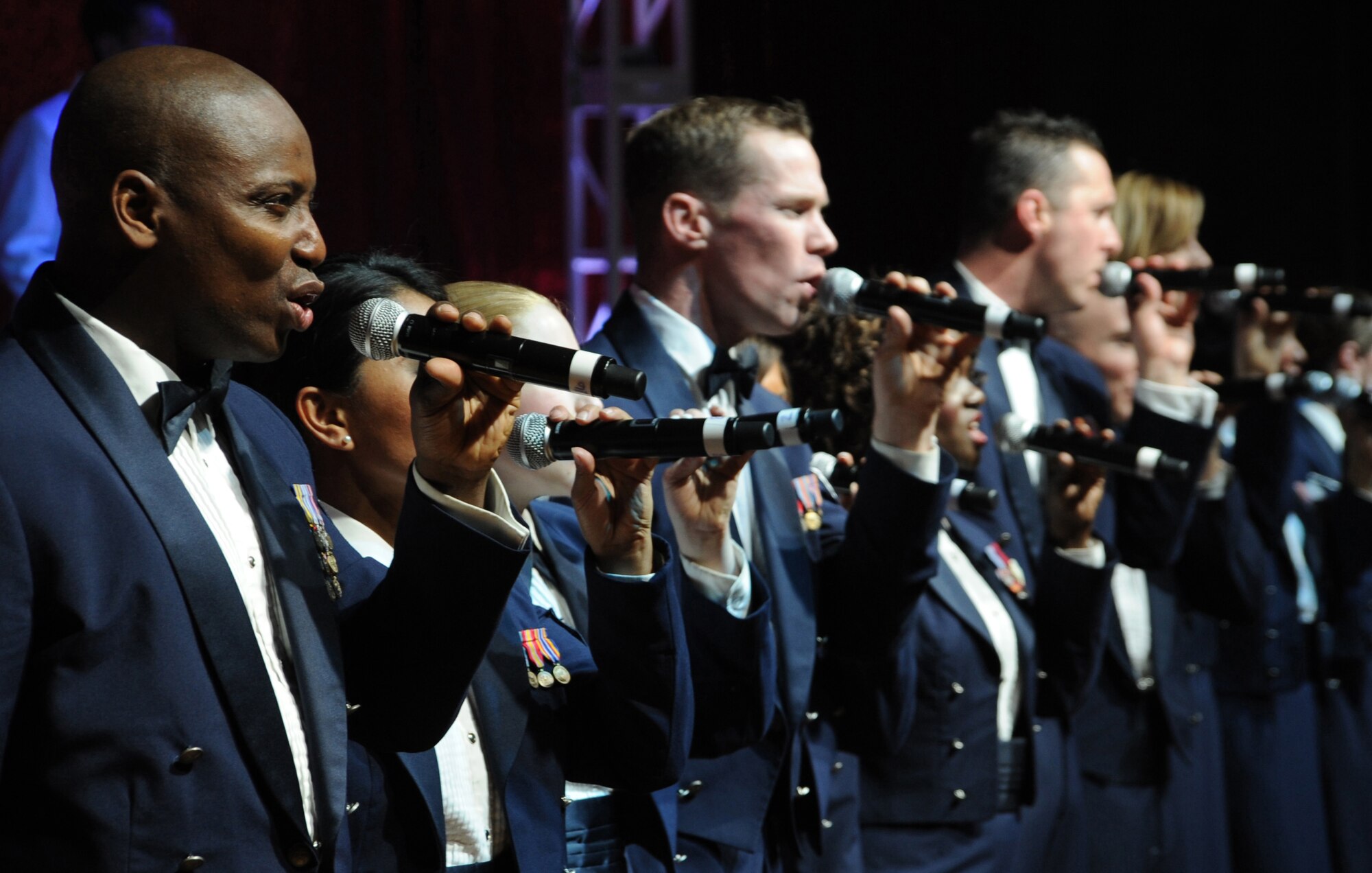 Tops in Blue performers end the night with a Tops in Blue tradition, "I'm proud to be an American", by Lee Greenwood. Each team begins their tour with an intense 45 day training period at Lackland Air Force Base, Texas, the home of Tops in Blue. (U.S. Air Force photo by Airman 1st Class Maynelinne De La Cruz)