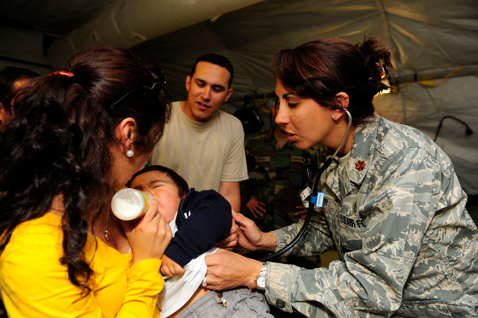 Major Deena Sutter, 59th Medical Wing at Lackland Air Force Base, Texas, checks the heartbeat of an ill child March 14, 2010, in Angol, Chile. Airmen from an Air Force Expeditionary Medical Support team along with members of the Chilean army built a mobile hospital here to help augment medical services for nearly 110,000 Chileans in the region. 