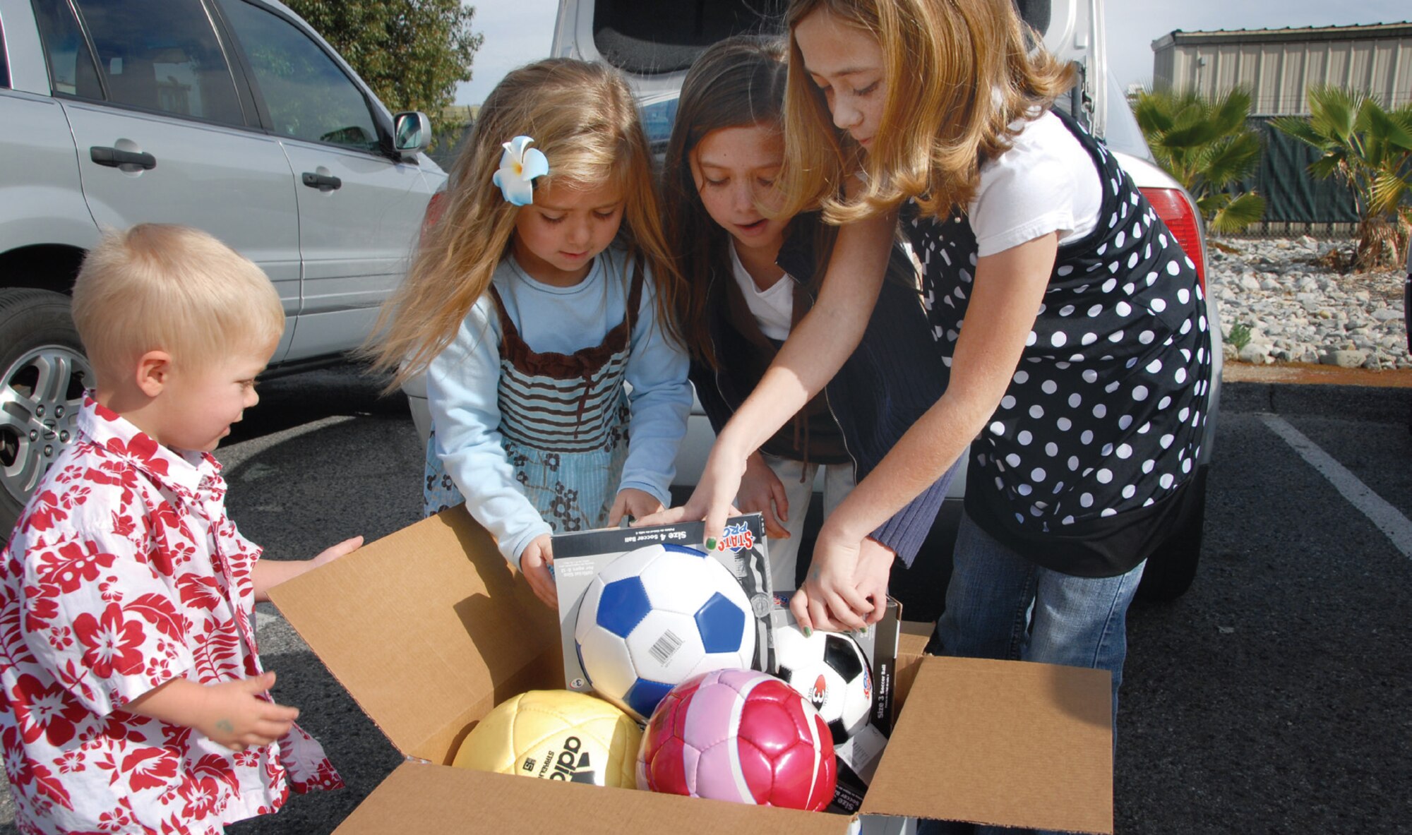 (from left) Elias, Whitney, Torrey and Denali Linton, children of Major Christopher Linton of the 163rd Reconnaissance Wing of the Air National Guard, pack soccer balls for shipment to Iraq. Denali raised the money to purchase the 10 soccer balls herself. The balls were mailed Jan. 29.  (U.S. Air Force Photo/ Staff Sgt. Paul Duquette)