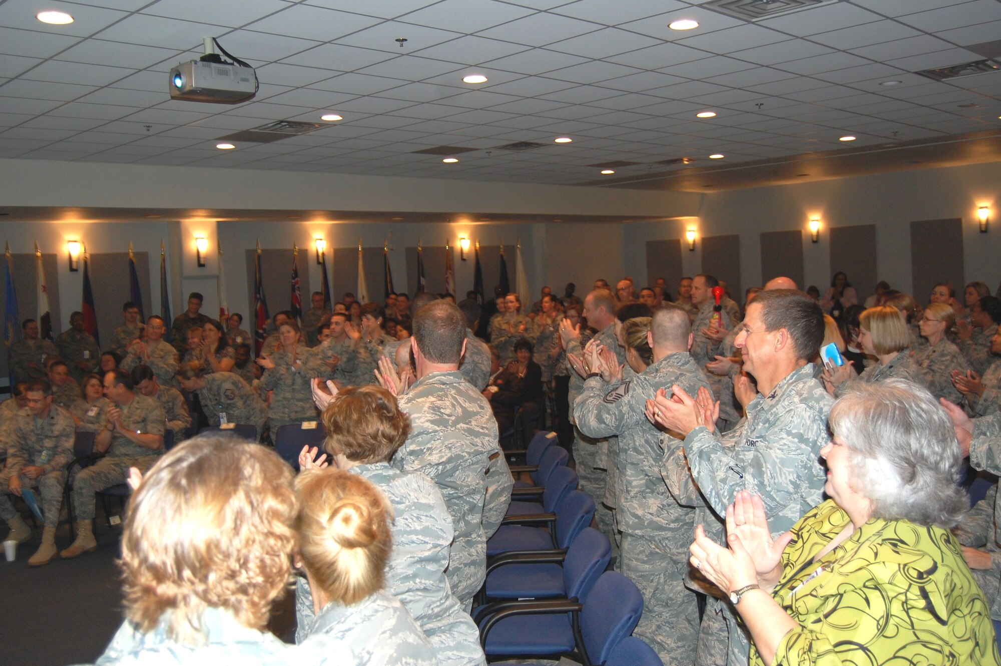 Members of the 81st Medical Group standing-room-only audience reacts as Col. Roger Hesselbrock, Air Force Inspection Agency Health Service Inspection team chief, announces the “Excellent” rating the nine-member team gave the 81st Medical Group during their March 12 official out brief. (Photo by Steve Pivnick
