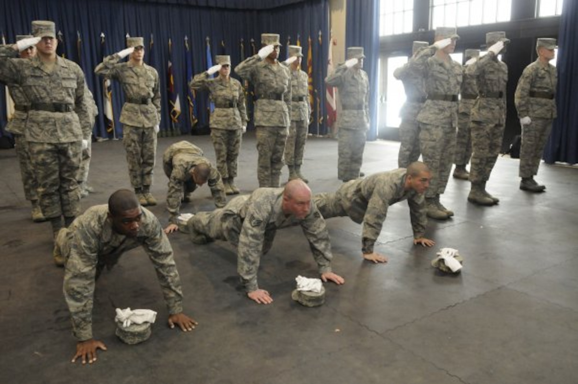 United States Air Force Honor Guard technical school trainees stay in the push-up position while the rest of the class holds their salute during practice, Feb. 22, 2010, inside the Honor Guard's C Hall on Bolling Air Force Base, D.C. While saluting, trainees are taught to not break bearing for any reason. As a form of discipline for mistakes, push-ups are a common practice among the honor guard technical school instructors. (U.S. Air Force photo by Senior Airman Marleah Miller)
