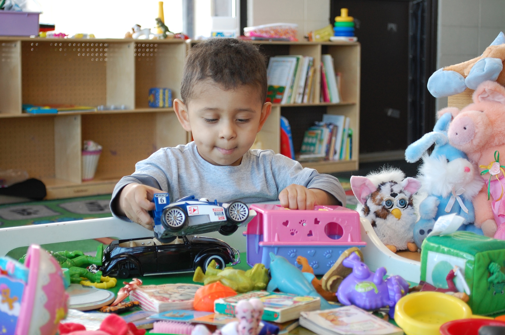 Two-year-old Adam plays with some of the toys that have been donated to the Airman's Attic while his mother "shops" for clothes for him. (U.S. Air Force photo/Valerie Mullett)
