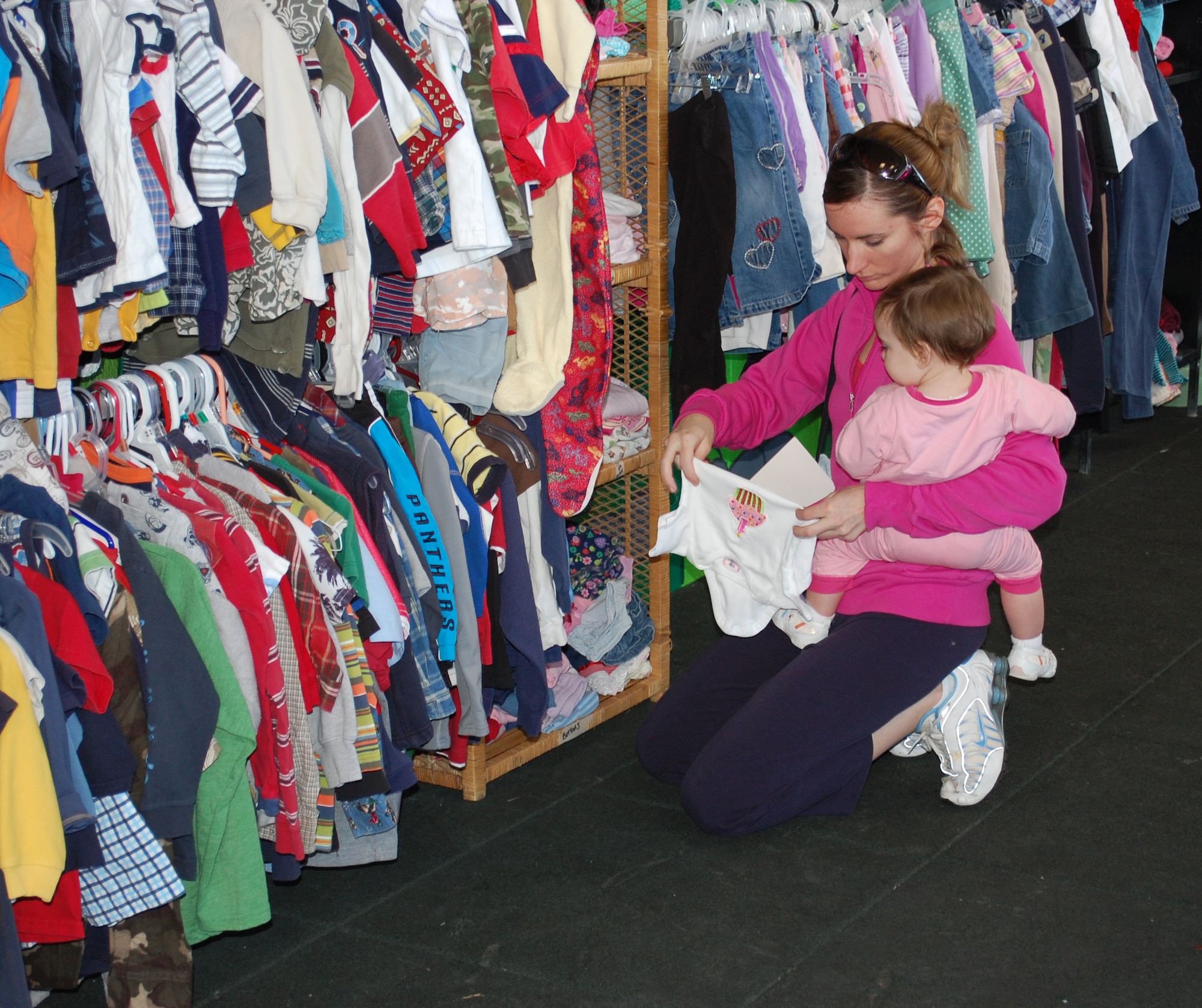 Cara Frank looks over the selection of "onesies" for her 11-month-old daughter, Haleigh, at the Airman's Attic March 4. All of the items in the Airman's Attic are free. (U.S. Air Force photo/Valerie Mullett)