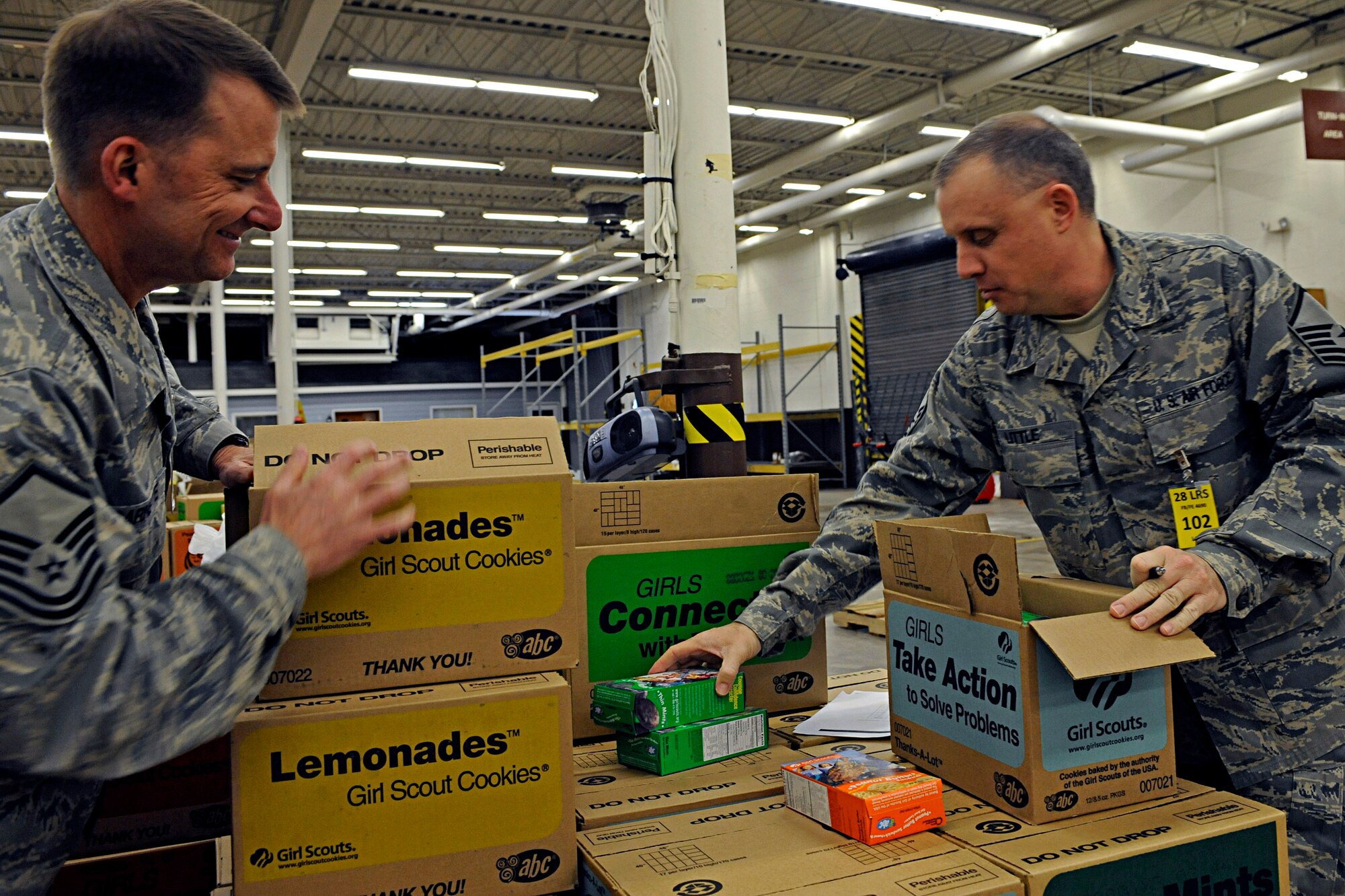 ELLSWORTH AIR FORCE BASE, S.D. -- (Left) Master Sgt. Danny Barnette, 28th Logistics Readiness Squadron, traffic management office supply liaison, and Master Sgt. William Little, 28 LRS compliance and analysis NCO in-charge, perform quality control inspections on orders of Girl Scout cookies, March 13. The 28 LRS have volunteered to organize cookie orders the past five years for the local Girl Scout troops. (U.S. Air Force photo/Airman 1st Class Matthew Flynn) 