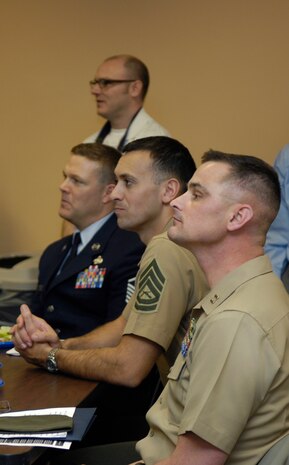 Master Sgt. Timothy Smith, Marine Gunnery Sgt. Jamie Nicholson and Marine Capt. Shawn Rickrode listen attentively at the Charleston Metro Chamber of Commerce Military/Defense Community benefit March 11. The benefit aimed to raise money to support and enable the chamber to work with area military organizations and local state and federal officials. Sergeant Smith is the 437th Logistics Readiness Squadron first sergeant, and Sergeant Nicholson and Captain Rickrode are Reserve Officers' Training Corps instructors at The Citadel. (U.S. Air Force photo/Airman 1st Class Lauren)
