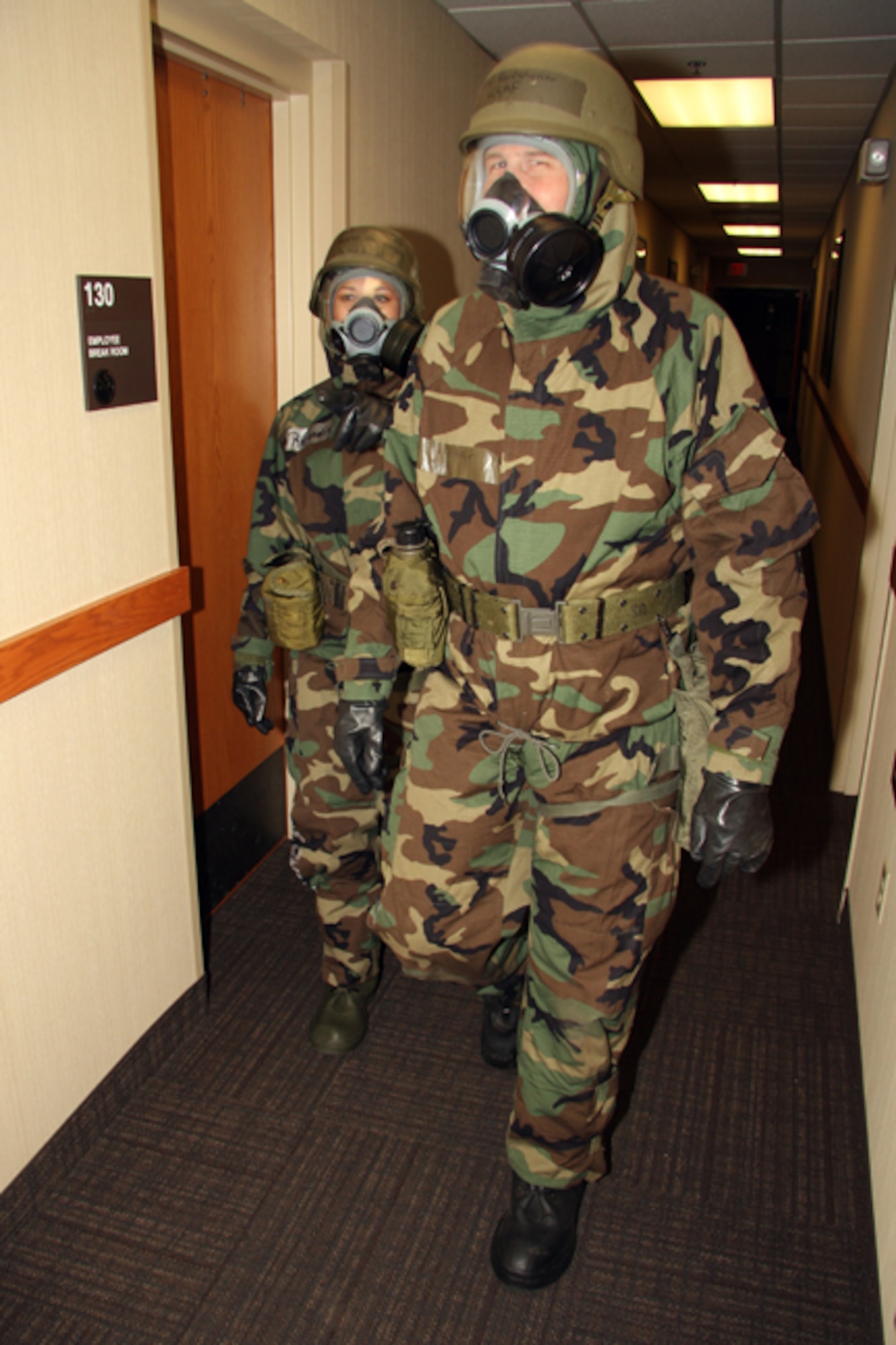 GRISSOM AIR RESERVE BASE, Ind. -- Master Sgts. Robert Berkstresser and Rocio Resendiz, 434th Services Flight services technicians, walk through the Grissom Services complex while completing task qualification training.  TQT helps keep Airmen familiar with their chemical protective overgarments and practice working in the specialized suits designed to protect personnel against chemical, biological, radiological and nuclear hazards and attacks.  (U.S. Air Force photo/Tech. Sgt. Mark Orders-Woempner)