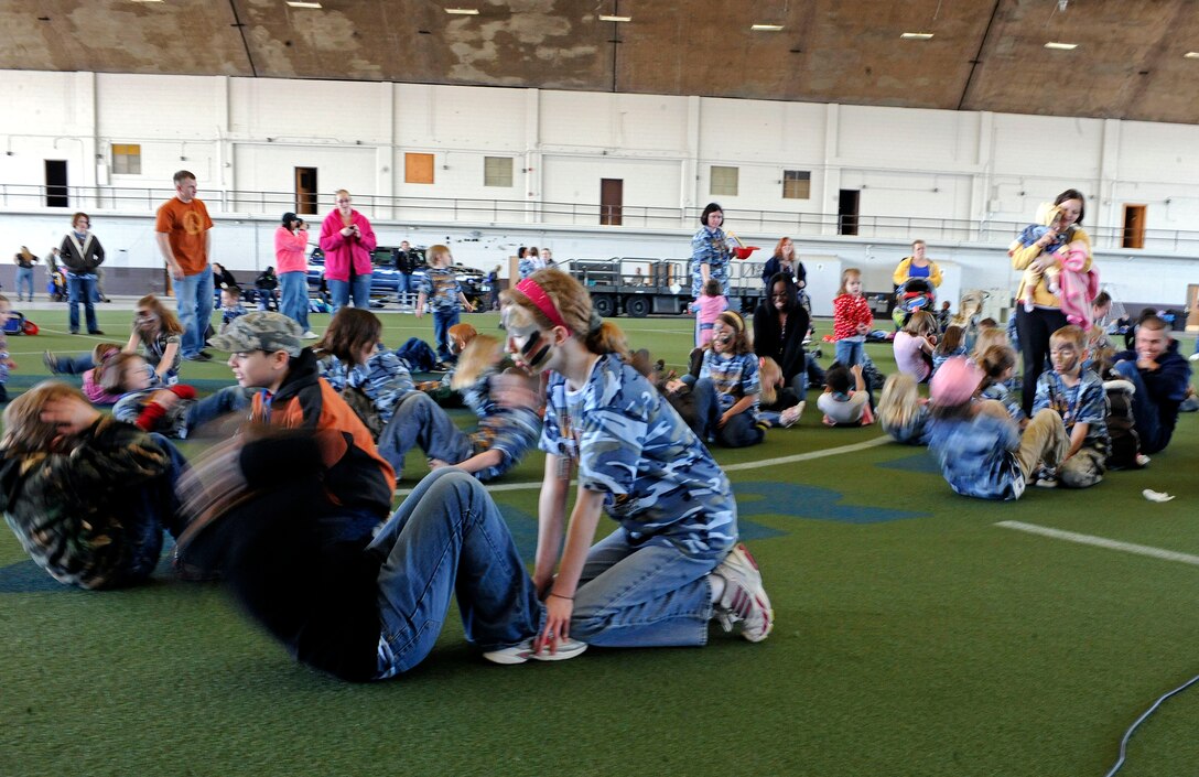 ELLSWORTH AIR FORCE BASE, S.D. -- Children of Ellsworth’s Airmen perform sit-ups during a physical training demonstration at the Kids, Spouses and Teachers Understanding Deployment Operations event, March 13. The demonstration showed the children how to work together and perform a proper sit-up. (U.S. Air Force photo/Airman 1st Class Matthew Flynn)