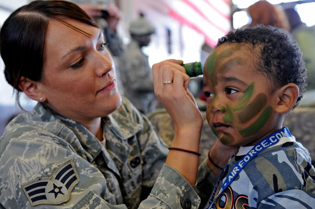 ELLSWORTH AIR FORCE BASE, S.D. -- Senior Airman Melanie Allen, 28th Security Forces Squadron training instructor, paints the face of a child during the Kids, Spouses and Teachers Understanding Deployment Operations event, March 13. The event featured various military demonstrations, a mock deployment line and a B-1B Lancer tour. (U.S. Air Force photo/Airman 1st Class Matthew Flynn)