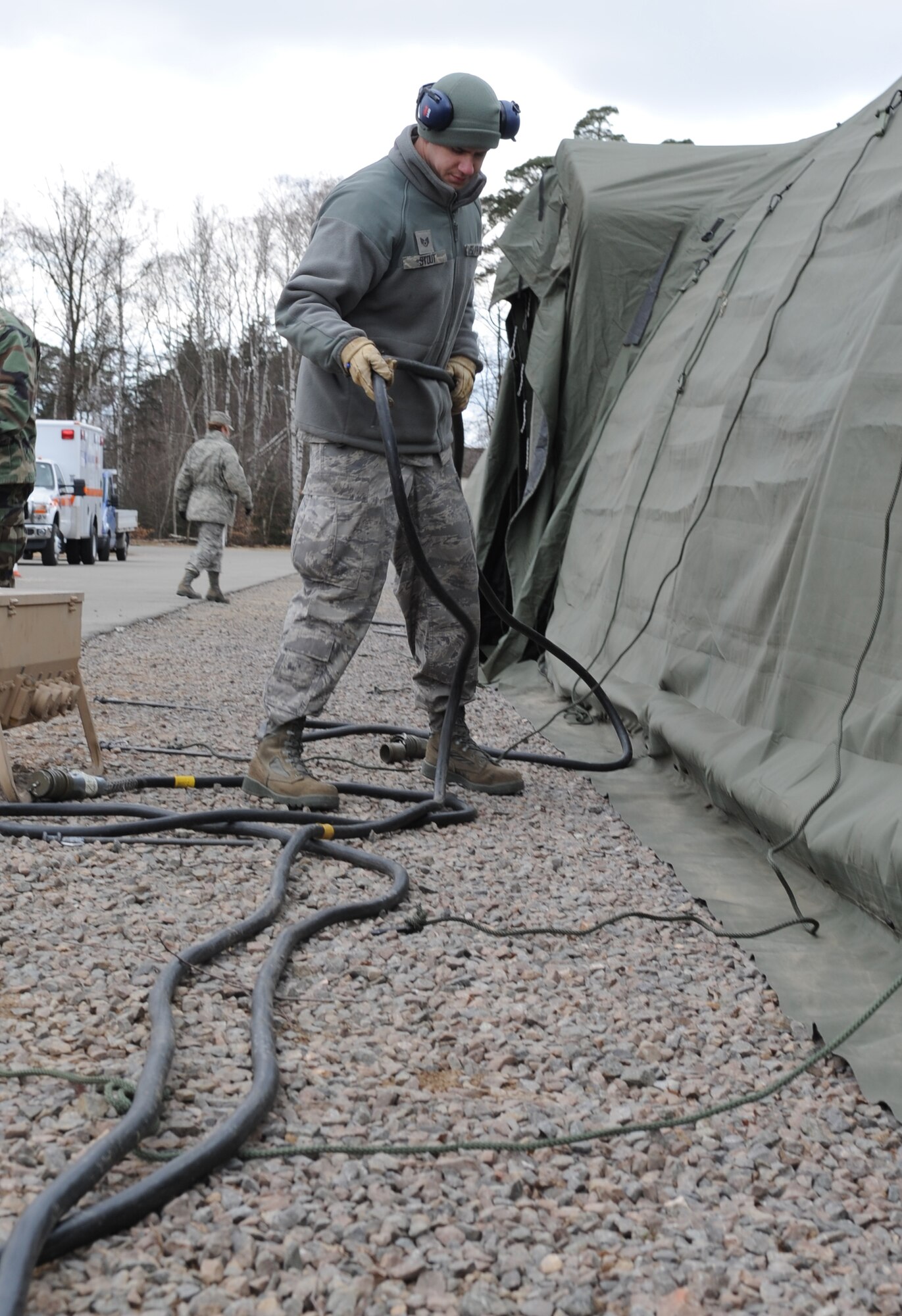 U.S. Air Force Staff. Sgt. Kaleb Stout, 86th Medical Support Squadron biomedical equipment technician, runs a main power cords that will be supplying power to tents during the tent build up portion of the Expeditionary Medical Support (EMEDS) Mobile Course Ramstein Air Base, Germany, March 15, 2010. The EMEDS course teaches and evaluates corps specific field situations as well as offers updates in Air Force Medical Service concept of operations and doctrine.  It also teaches setup and packing out of a field EMEDS compound, deployed operations, field medical, nursing and operational support equipment proficiency, field exercises to both emphasize and evaluate learning of concepts taught. (U.S. Air Force photo by Airman 1st Class Caleb Pierce)