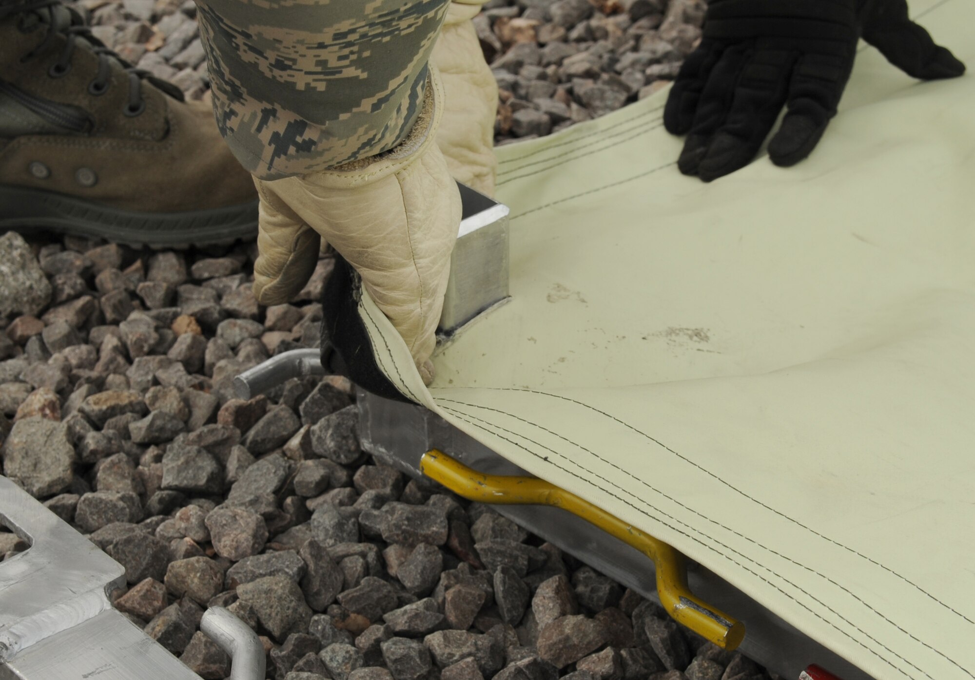 U.S. Air Force medical members participating in the Expeditionary Medical Support (EMEDS) Mobile Course spread out tent tarp over frames during the tent build up portion of EMEDS, Ramstein Air Base, Germany, March 15, 2010. The EMEDS course teaches and evaluates corps specific field situations as well as offers updates in Air Force Medical Service concept of operations and doctrine.  It also teaches setup and packing out of a field EMEDS compound, deployed operations, field medical, nursing and operational support equipment proficiency, field exercises to both emphasize and evaluate learning of concepts taught. (U.S. Air Force photo by Airman 1st Class Caleb Pierce)