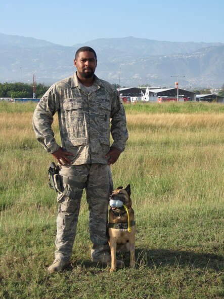 PORT-AU-PRINCE, Haiti -- Staff Sgt. Mckinzie Nash, 823rd Expeditionary Security Forces Squadron military working dog handler, poses with his canine partner here March 8. As part of their mission in providing security at the Toussaint L'Ouverture International Airport in Port-au-Prince, Haiti, MWD teams searched more than 3,000 vehicles and 2,500 pieces of luggage. (U.S. Air Force photo by Staff Sgt. Jack Carr)