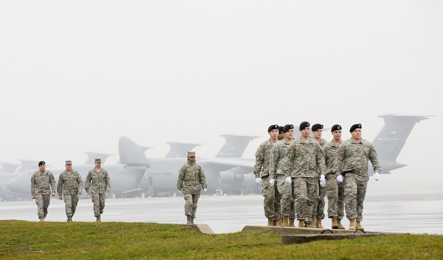 Brig. Gen. Kenneth Roberts (from left), special assistant for the director of the Army National Guard; Gen. Carrol H. "Howie" Chandler, vice chief of staff of the Air Force; and Col. Manson Morris, 436th Airlift Wing commander; Senior Airman Dawn Tunnell, transfer vehicle guide; and members from the 3rd U.S. Infantry, The Old Guard, return from the dignified transfer of two fallen servicemembers of Operation Enduring Freedom March 12, 2010, at Dover Air Force Base, Del.  A dignified transfer is the process where, upon the return from the theater of operations to the U.S., a fallen military member is transferred from the aircraft to a waiting vehicle and then to the Air Force Mortuary Affairs Operations Center. The center staff is charged with fulfilling the nation's sacred commitment of ensuring dignity, honor and respect to the fallen and care, service and support to their families. General Chandler and his wife, Eva-Marie, toured the center, participated in a dignified transfer and met family members of the fallen. (U.S. Air Force photo/Jason Minto)