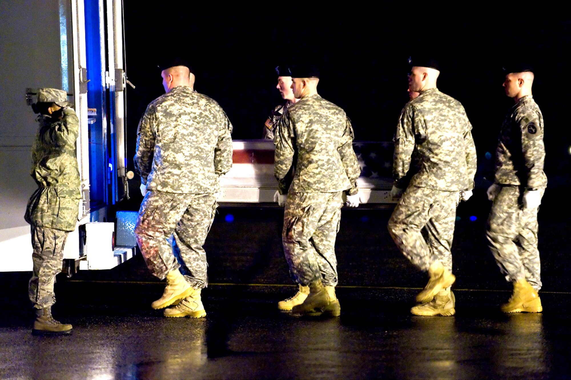 An Army carry team places a transfer case containing a fallen servicemember into a vehicle during a “dignified transfer” at Dover Air Force Base, Del., Feb. 22.. The vehicle will transport the case to the Air Force Mortuary Affairs Operations Center, where all U.S. servicemembers killed in combat are prepared for burial. (U.S. Air Force photo/Roland Balik) 