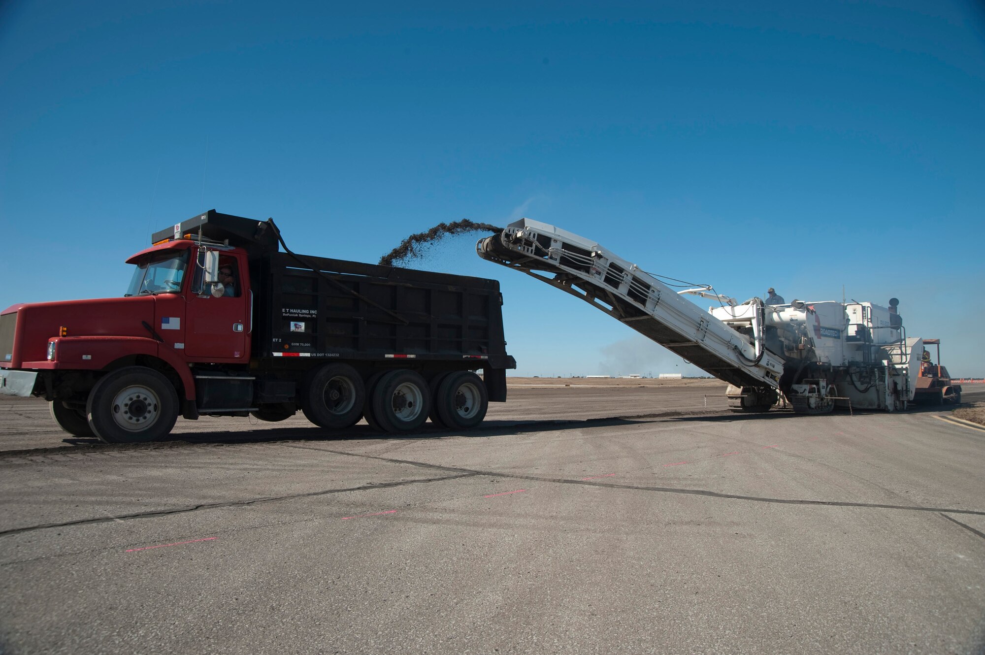 Asphalt is ground up and shot out by the RX-900 in February at Eglin Air Force Base, Fla.  This was part of the six-month repaving and construction on Runway 19/01.  The runway reopened March 15 to air traffic.  (Courtesy photo.)